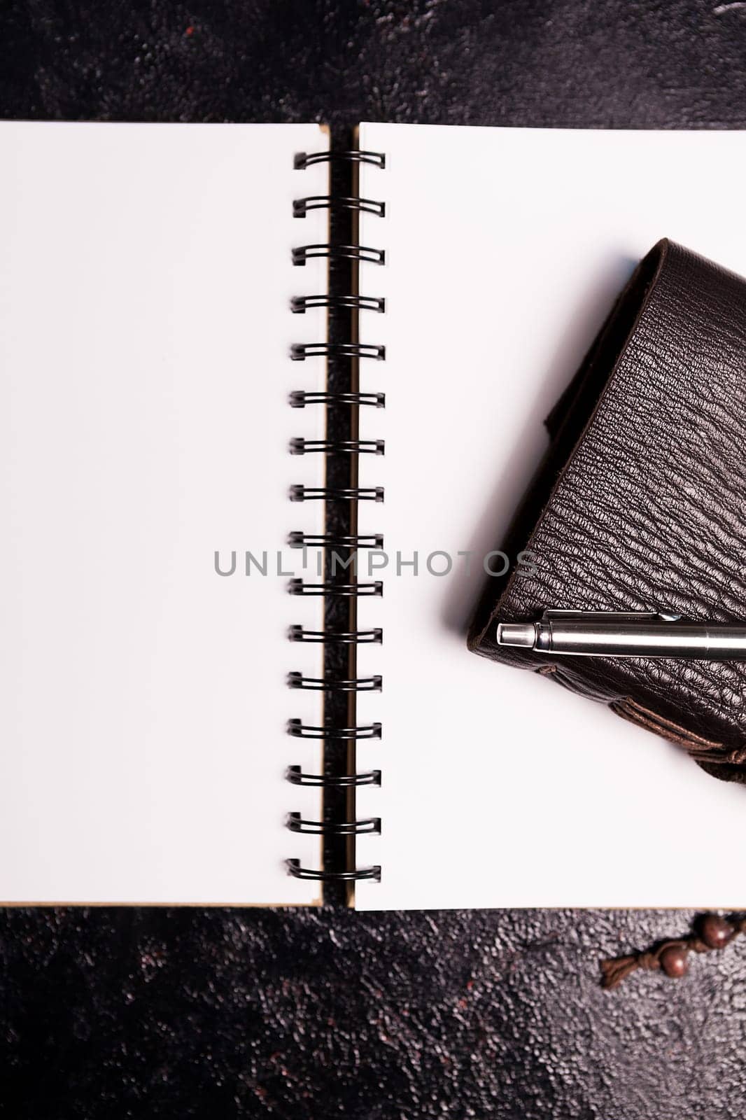 Leather covered vintage ntoebook on an open diary on a dark wooden board