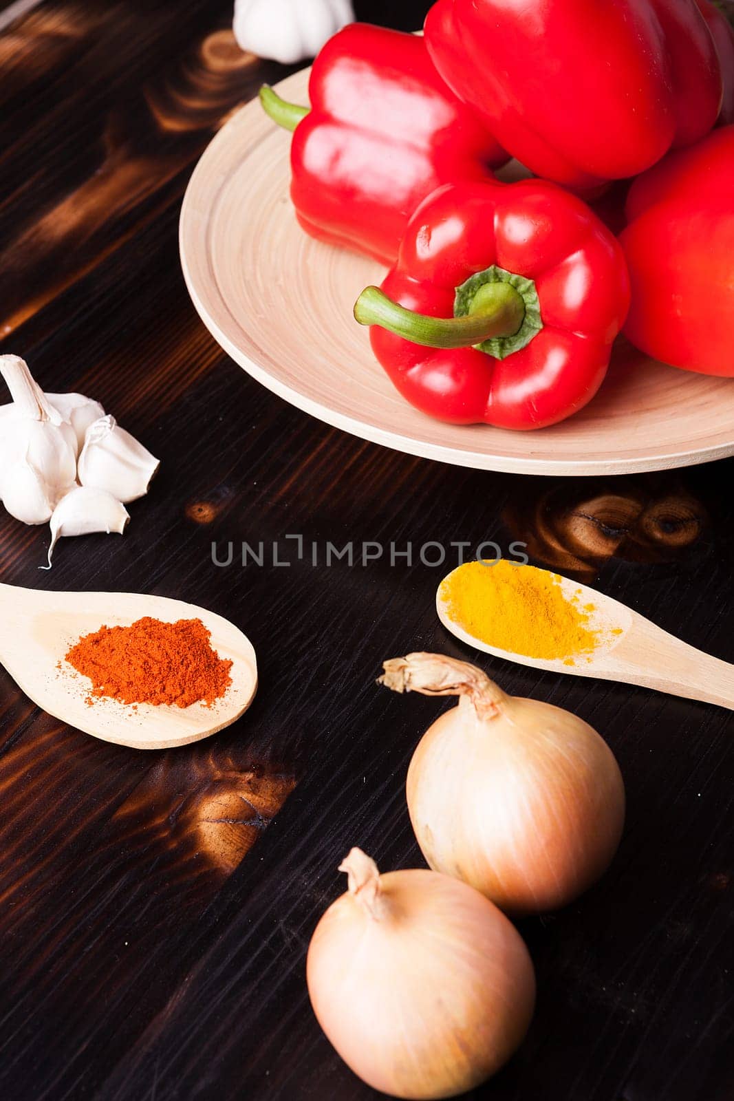 Vegetables and powder spices on burned wooden board