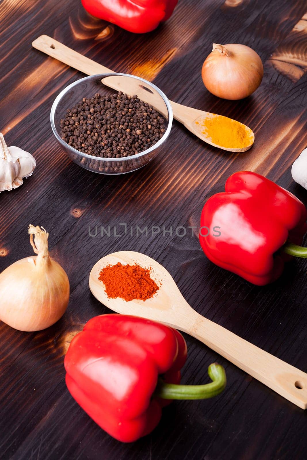 Fresh delicious vegetables and black pepper and other spices on burned wooden board