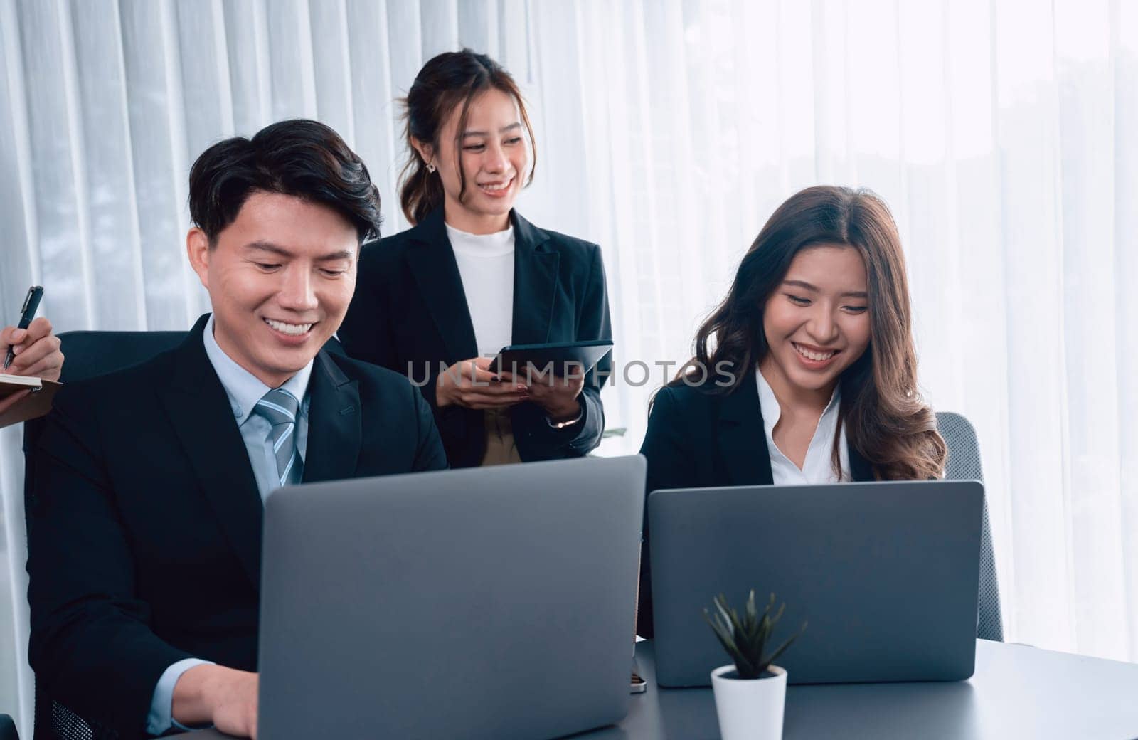 Harmony in office concept as business people analyzing dashboard paper together in workplace. Young colleagues give ideas at manager desk for discussion or strategy planning about project.