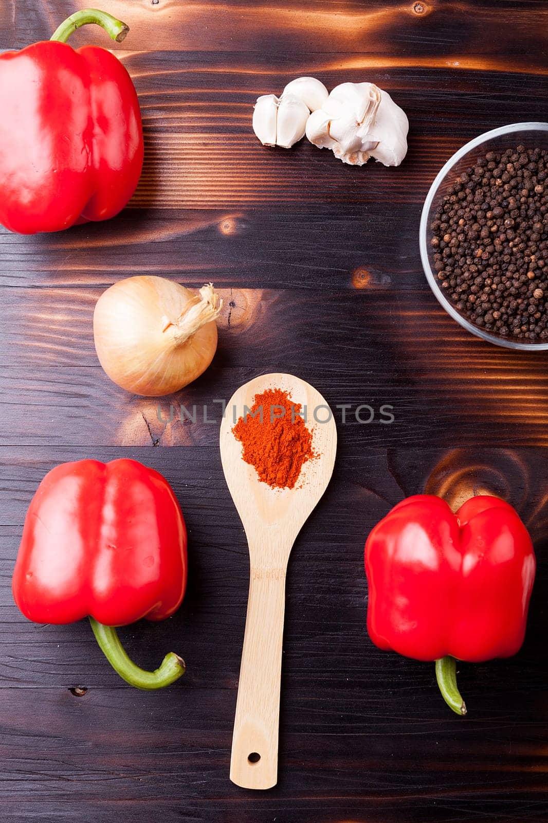 Fresh delicious vegetables and black pepper and other spices on burned wooden board