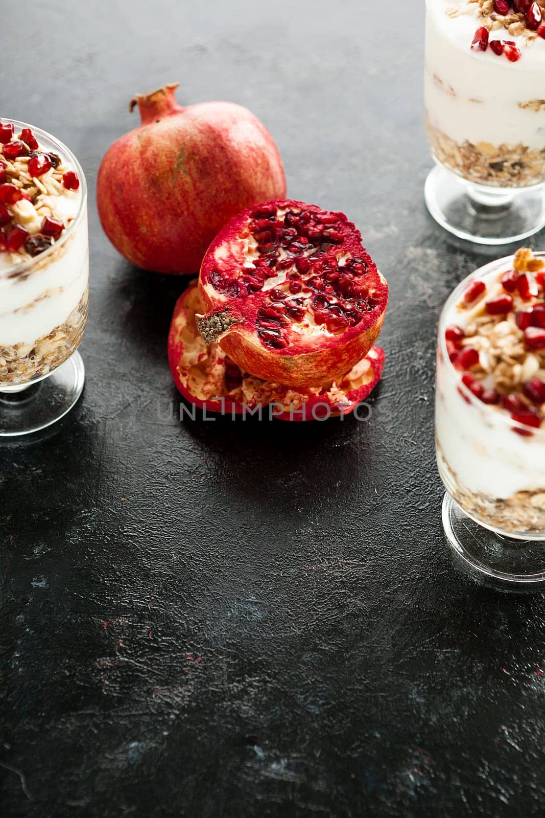 Pomegranate in the middle of home made desset on dark wooden background