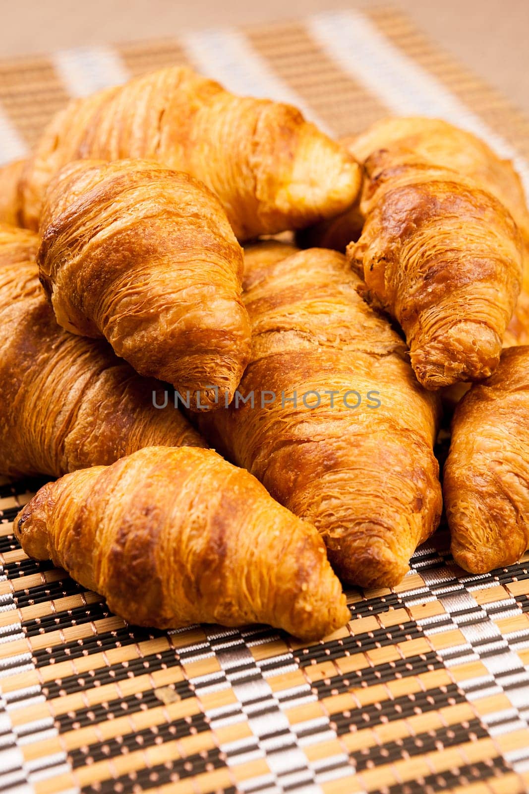 Close up on fresh baked golden croissants lying on a tables