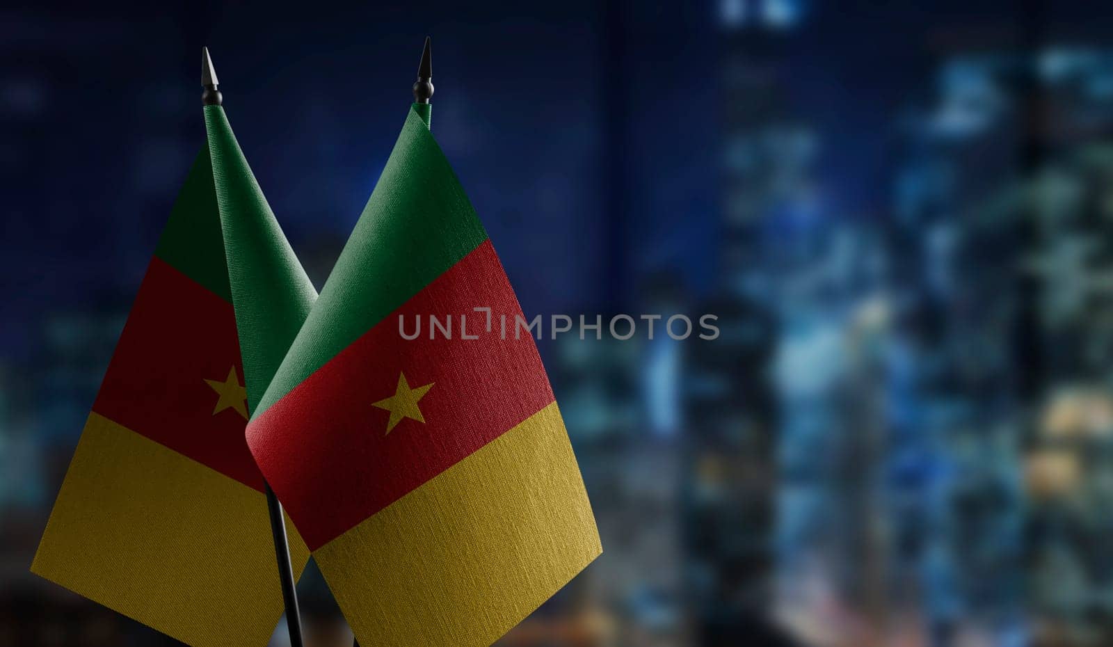Small flags of the Cameroon on an abstract blurry background.