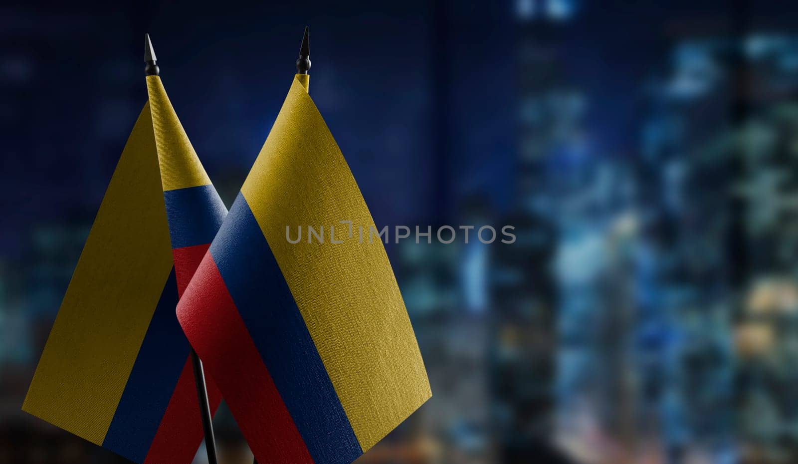Small flags of the Colombia on an abstract blurry background.