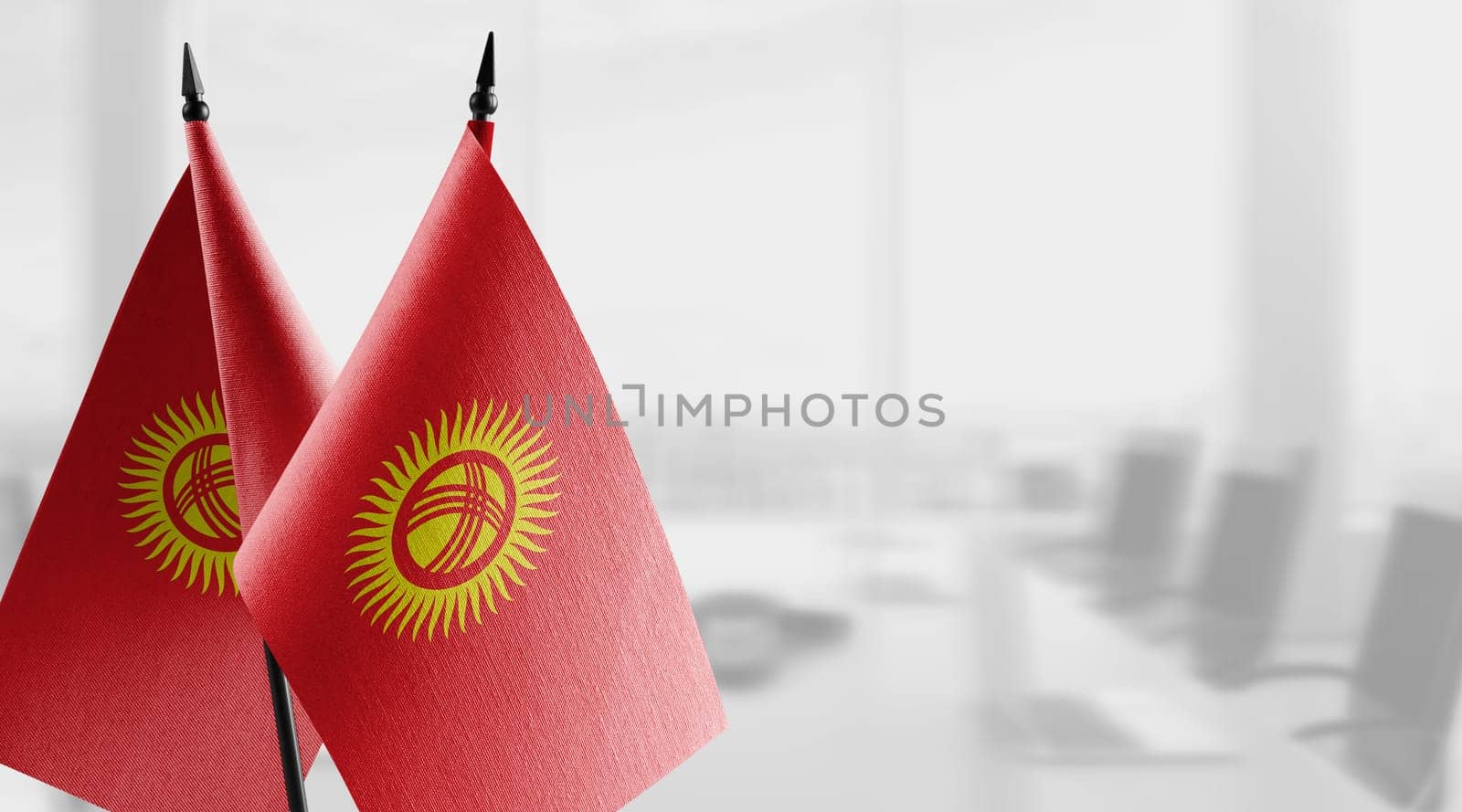 Small flags of the Kirghizia on an abstract blurry background.