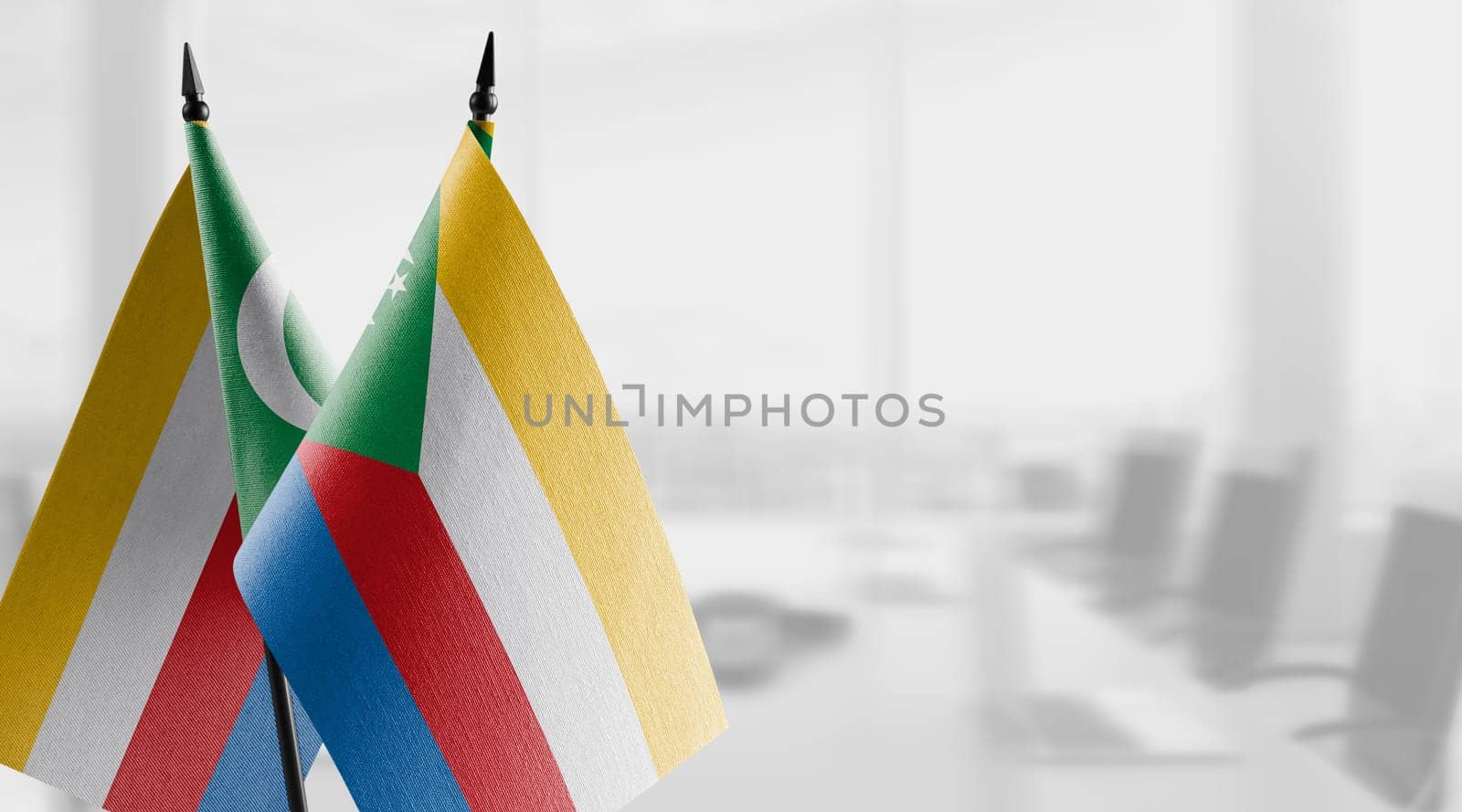 Small flags of the Comoros on an abstract blurry background.