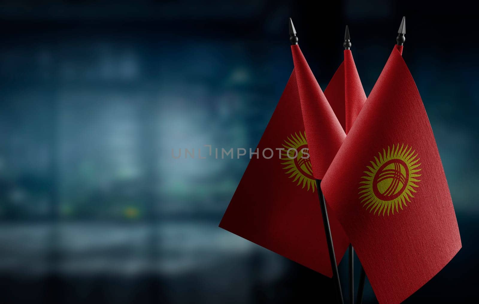 Small flags of the Kirghizia on an abstract blurry background.