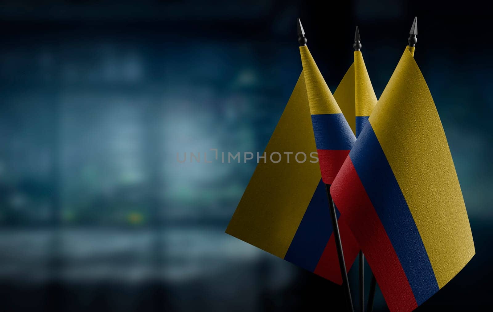 Small flags of the Colombia on an abstract blurry background.