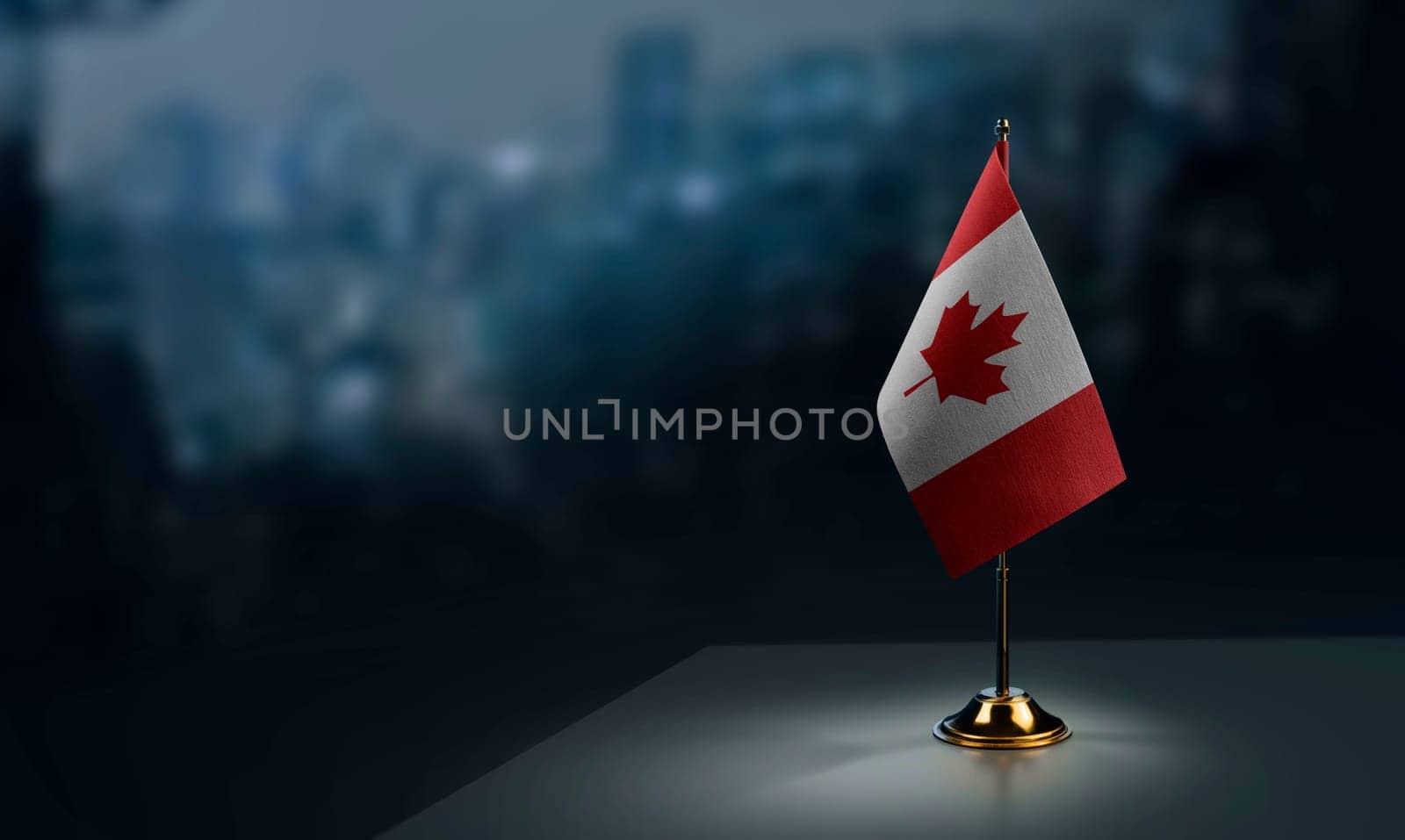 Small flags of the Canada on an abstract blurry background.