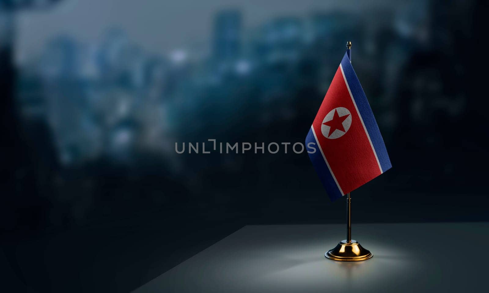 Small flags of the North Korea on an abstract blurry background.