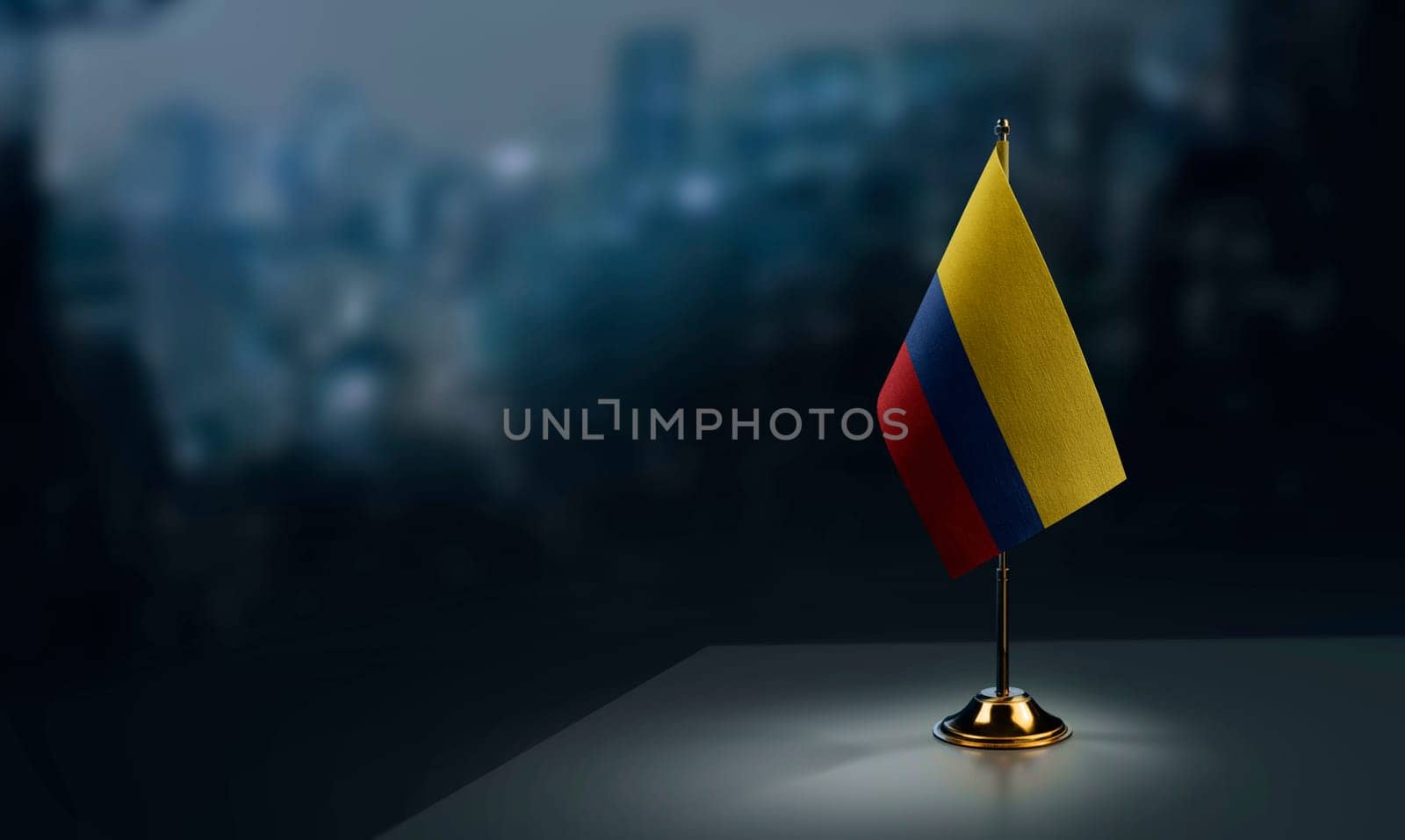 Small flags of the Colombia on an abstract blurry background.