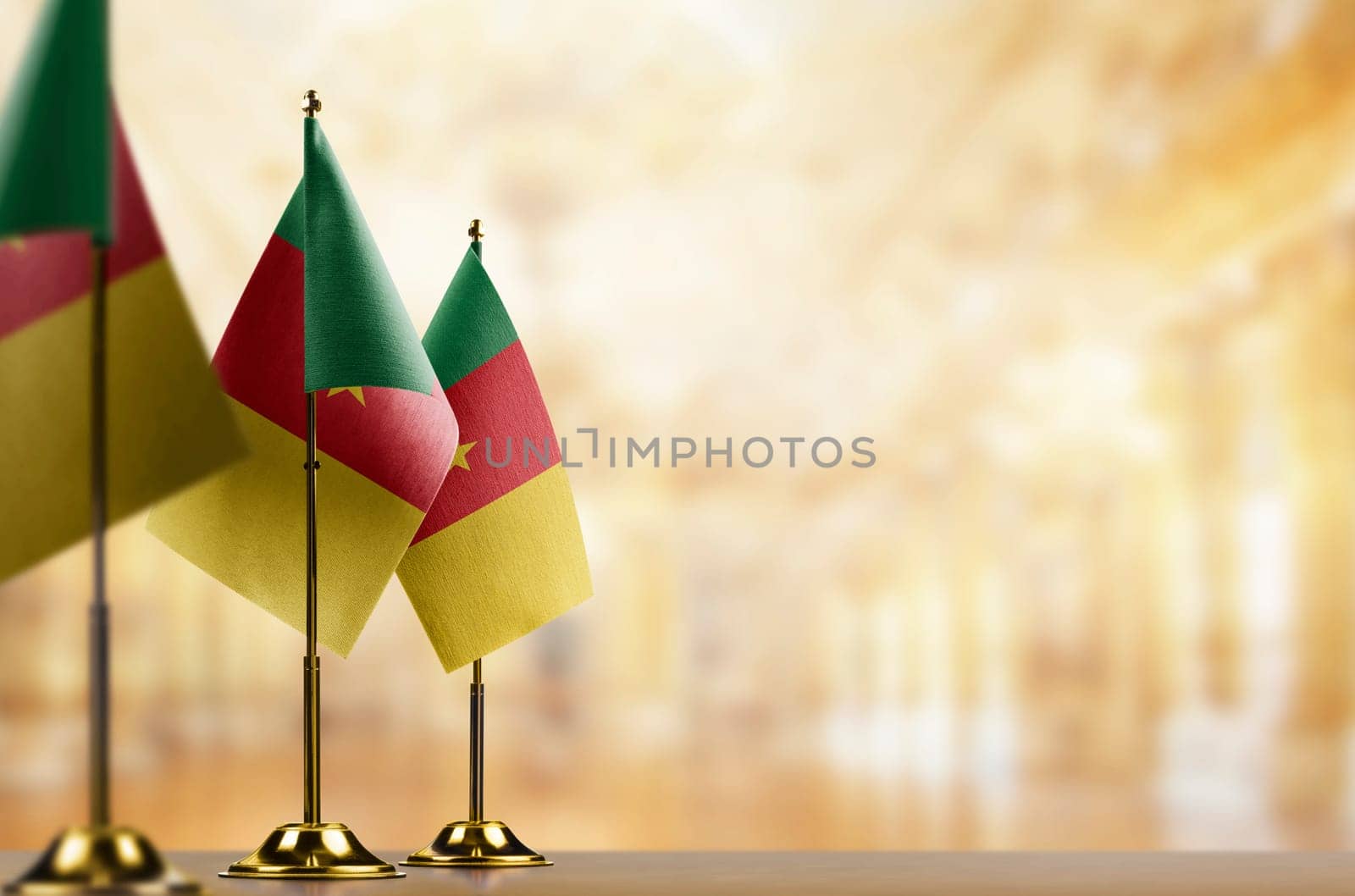 Small flags of the Cameroon on an abstract blurry background.