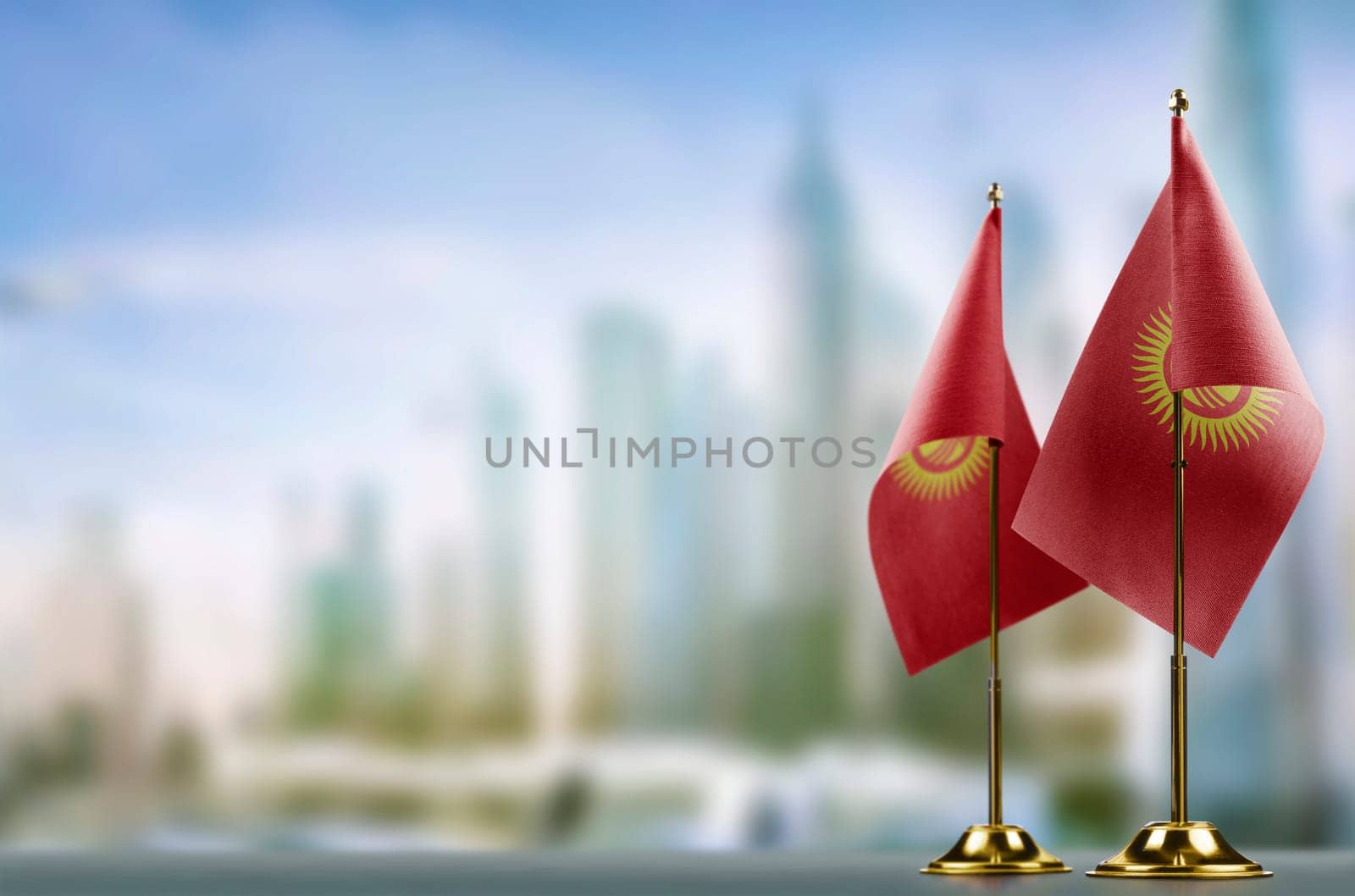 Small flags of the Kirghizia on an abstract blurry background.