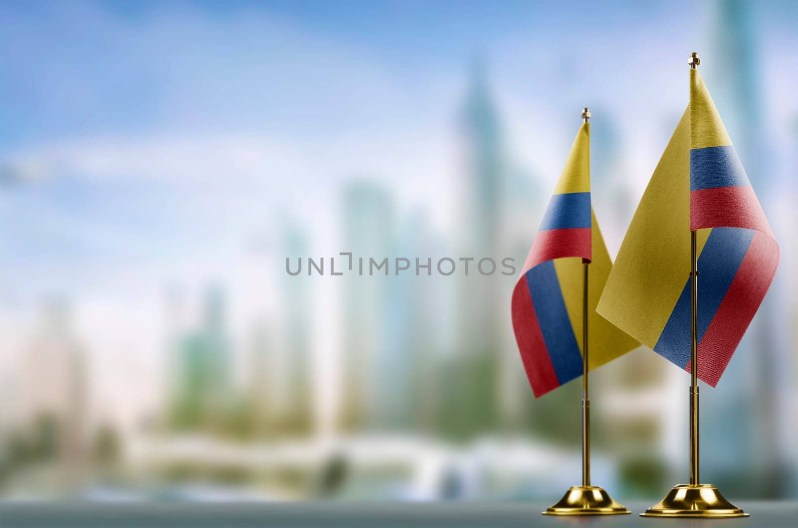 Small flags of the Colombia on an abstract blurry background.