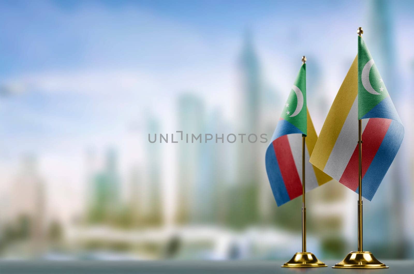 Small flags of the Comoros on an abstract blurry background.