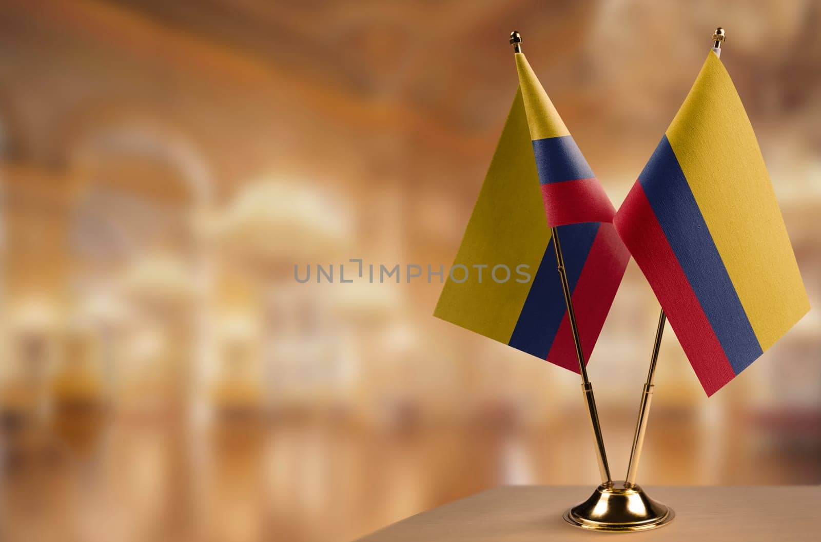 Small flags of the Colombia on an abstract blurry background.