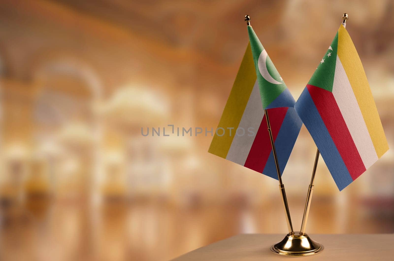 Small flags of the Comoros on an abstract blurry background.