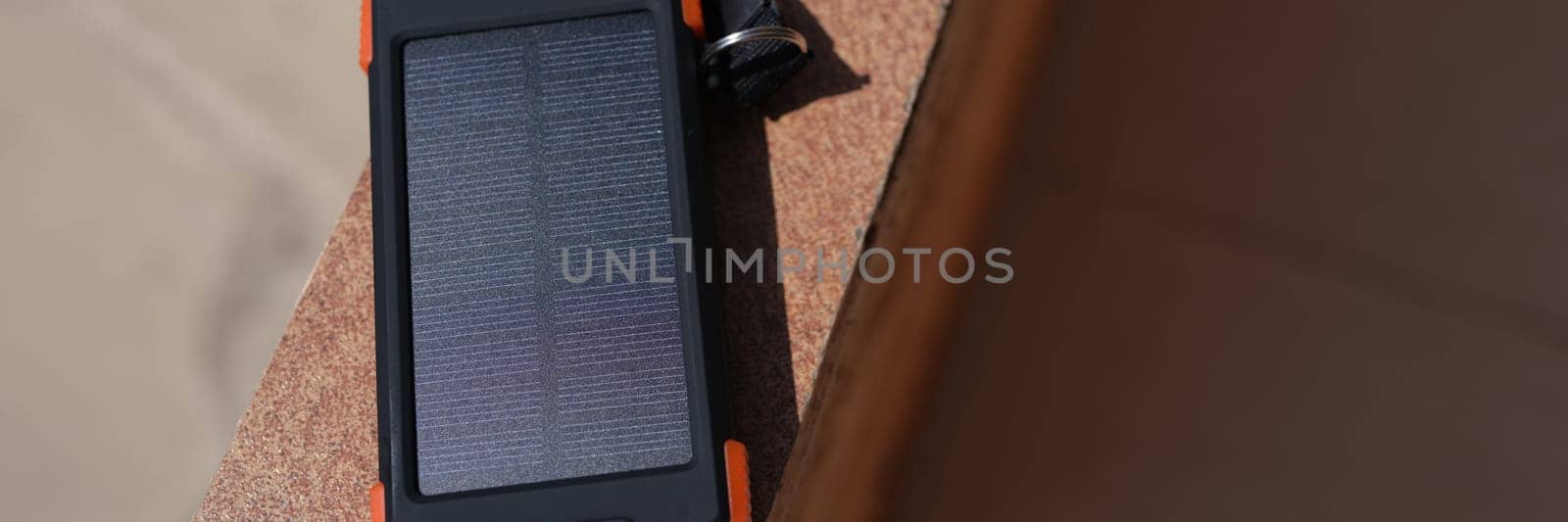 Solar power bank recharging by sunlight outdoor closeup. Environmental protection energy saving concept