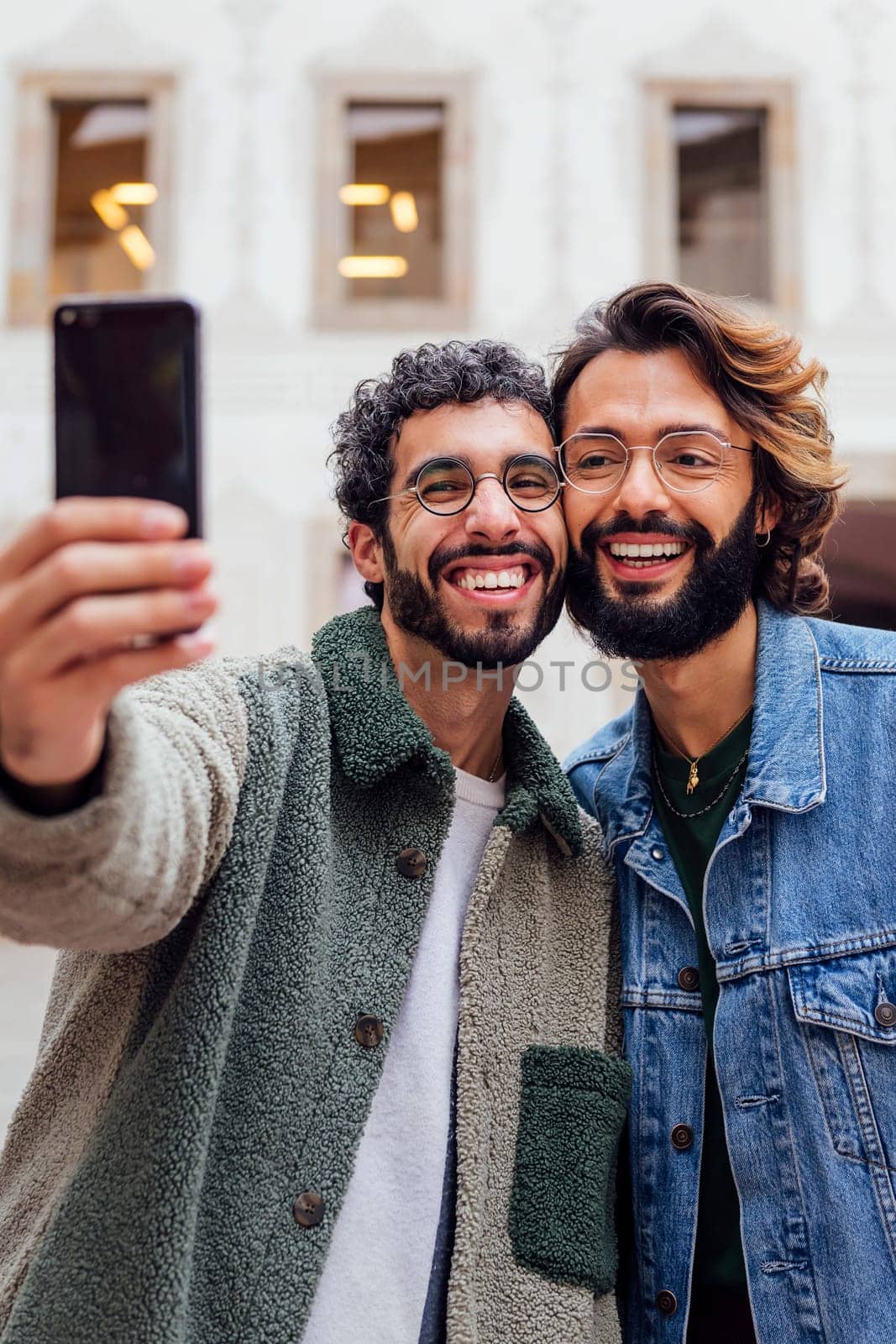happy couple of gay men taking a selfie photo by raulmelldo