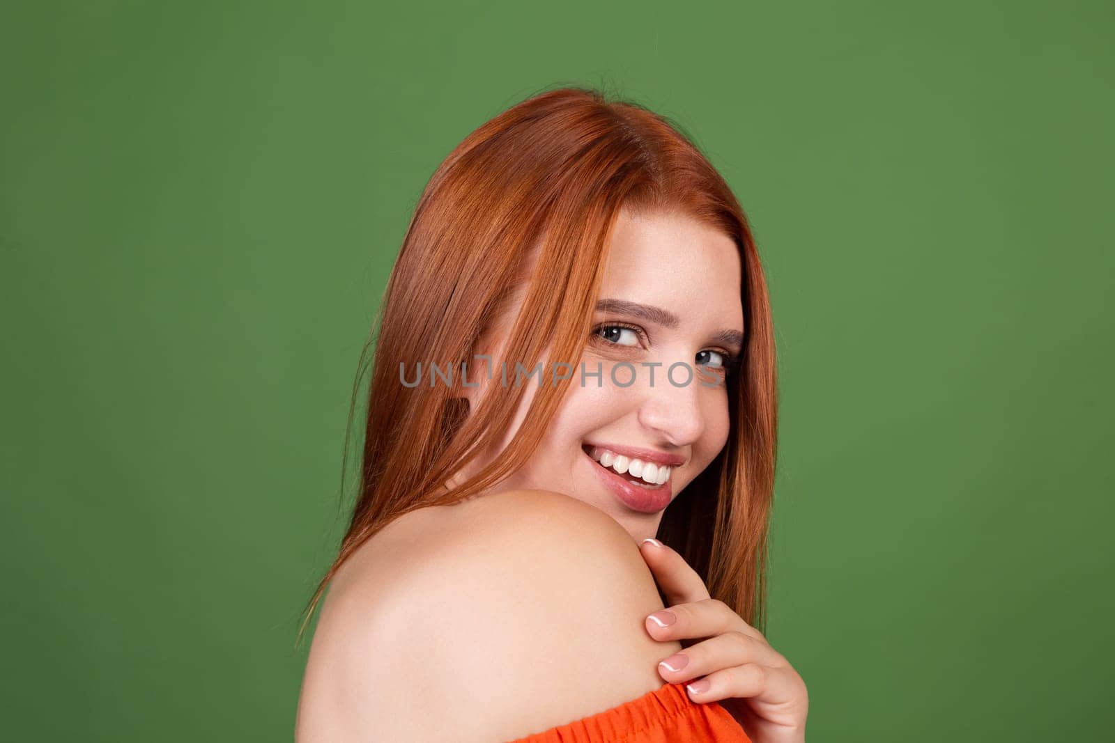 Portrait of pretty red hair young woman with smooth natural soft skin with bare shoulders on green background, beauty concept by kroshka_nastya