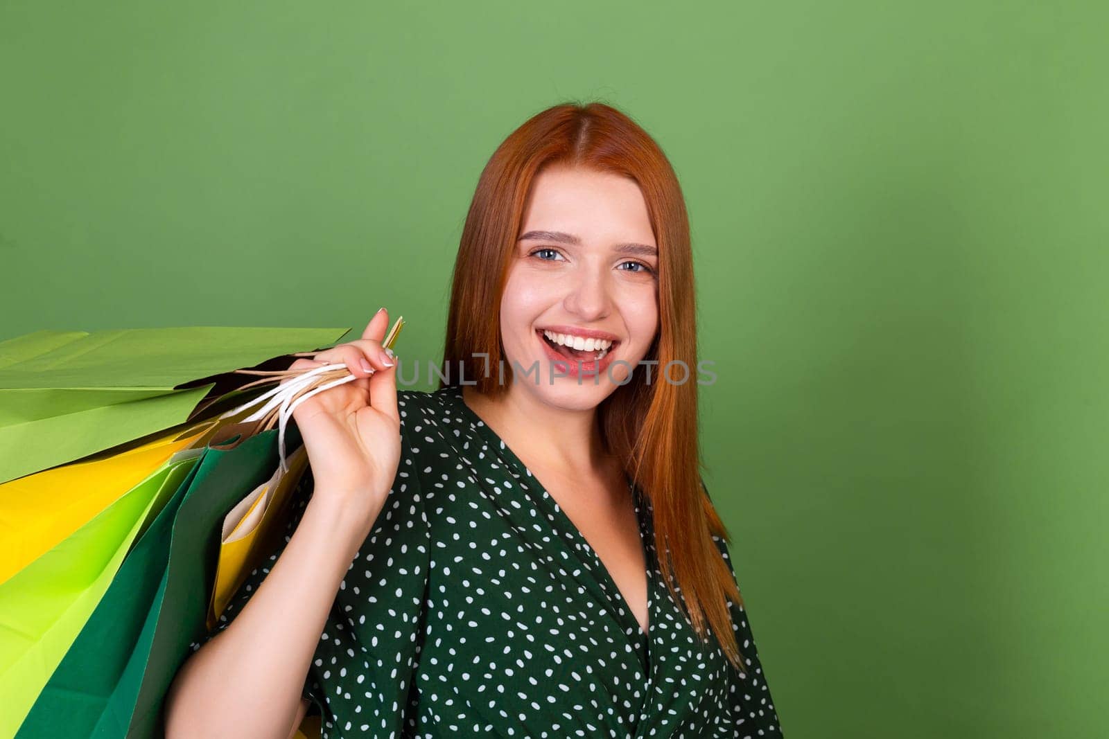 Young red hair woman on green background with shopping bags happy cheerful excited by kroshka_nastya