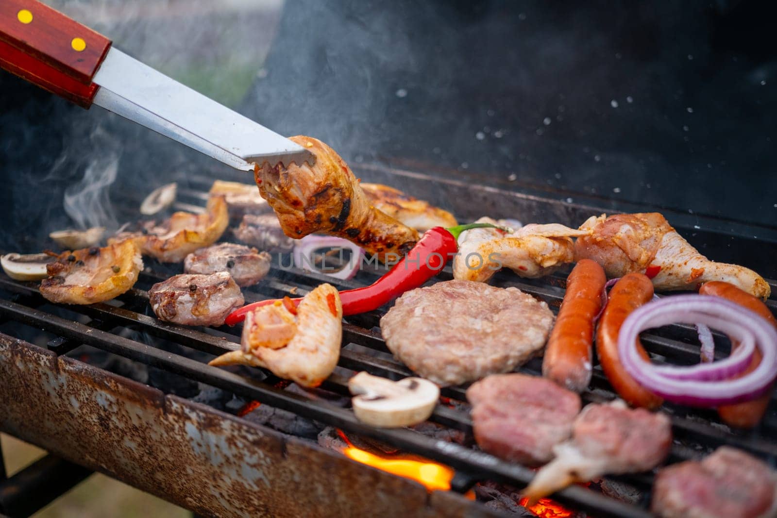 Assorted delicious grilled meat with vegetables over the coals on a barbecue. High quality photo