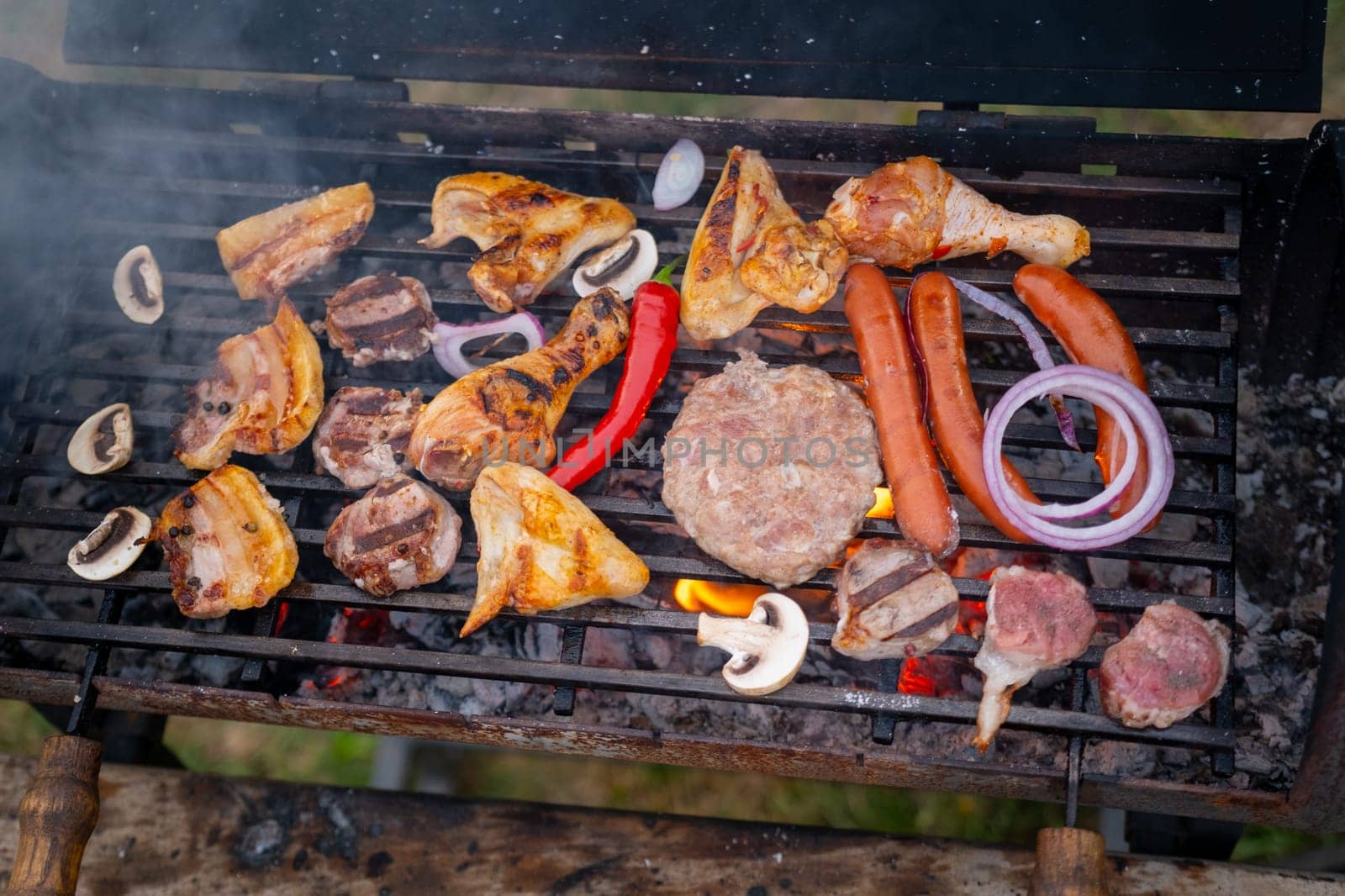 Assorted delicious grilled meat with vegetables over the coals on a barbecue. High quality photo