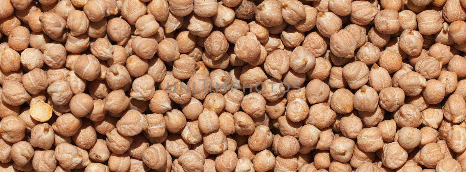 Raw chickpea beans. Top view on chickpea seeds. Food background from a texture of raw chickpeas close-up, top view. Uncooked chickpea. healthy food banner. by EvgeniyQW