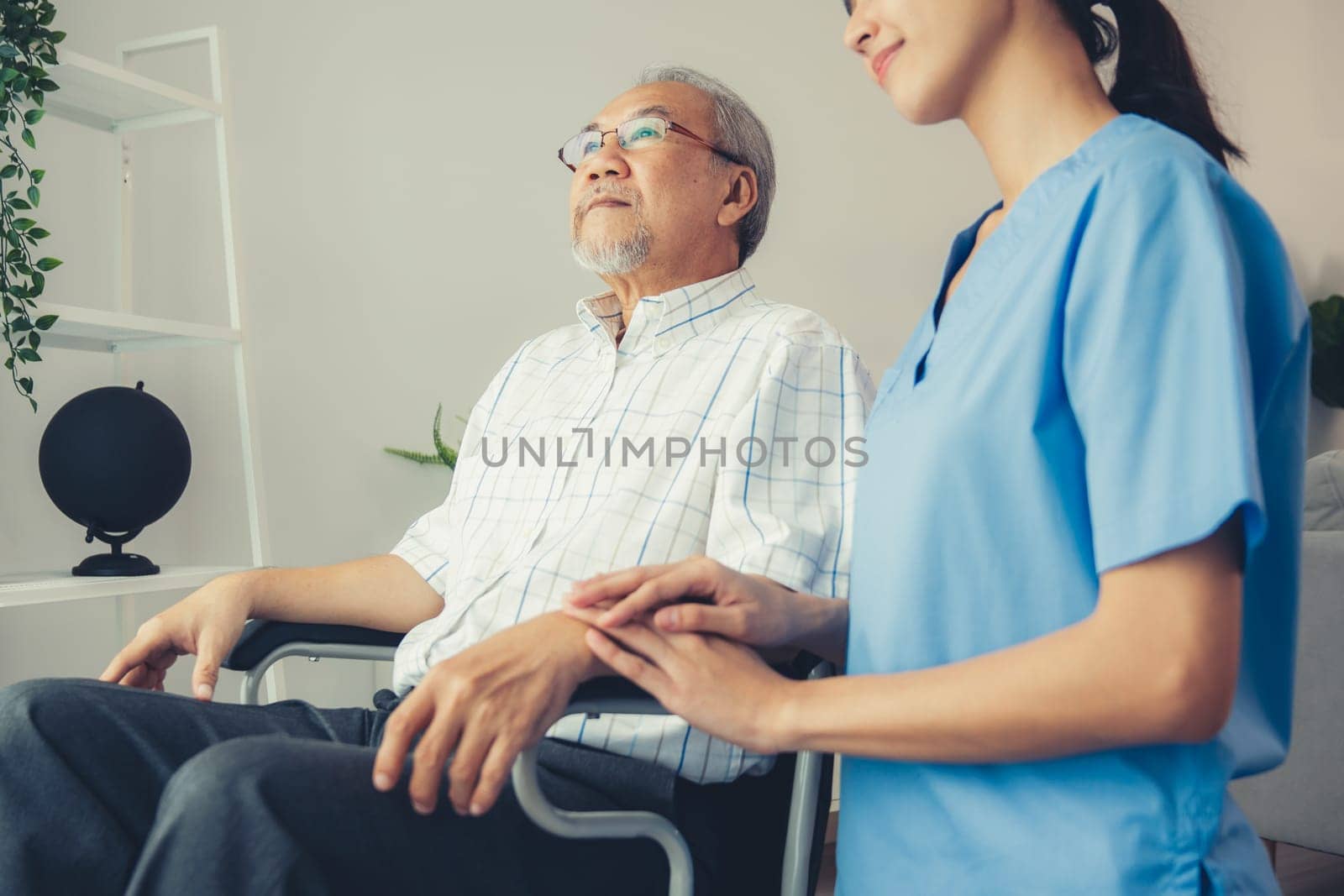 Caring nurse and a contented senior man in a wheel chair at home, nursing house. Medical for elderly patient, home care for pensioners.