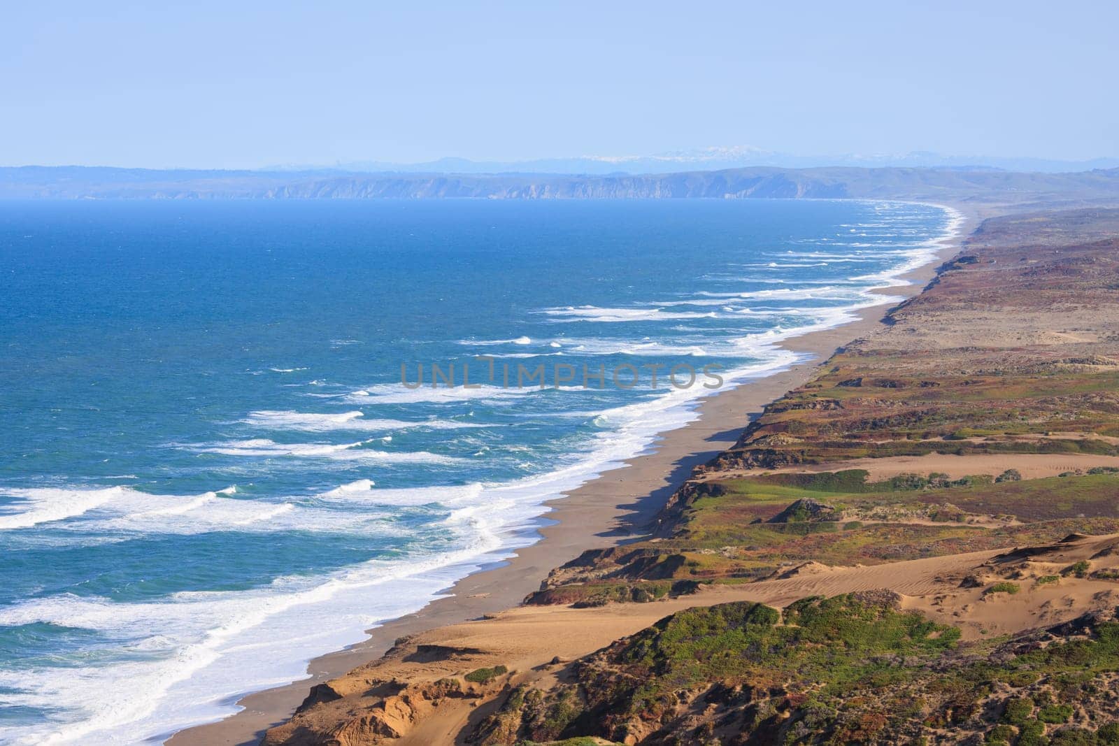 View of long sandy beach and cliffs of Point Reyes on Northern California coast. High quality photo