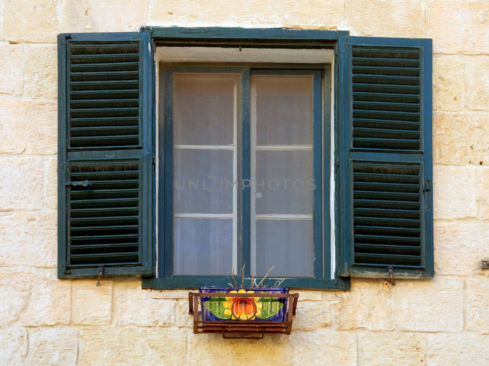 Fragment of the building's facade with traditional wooden ornate balconies painted in Valletta, Malta. High quality photo