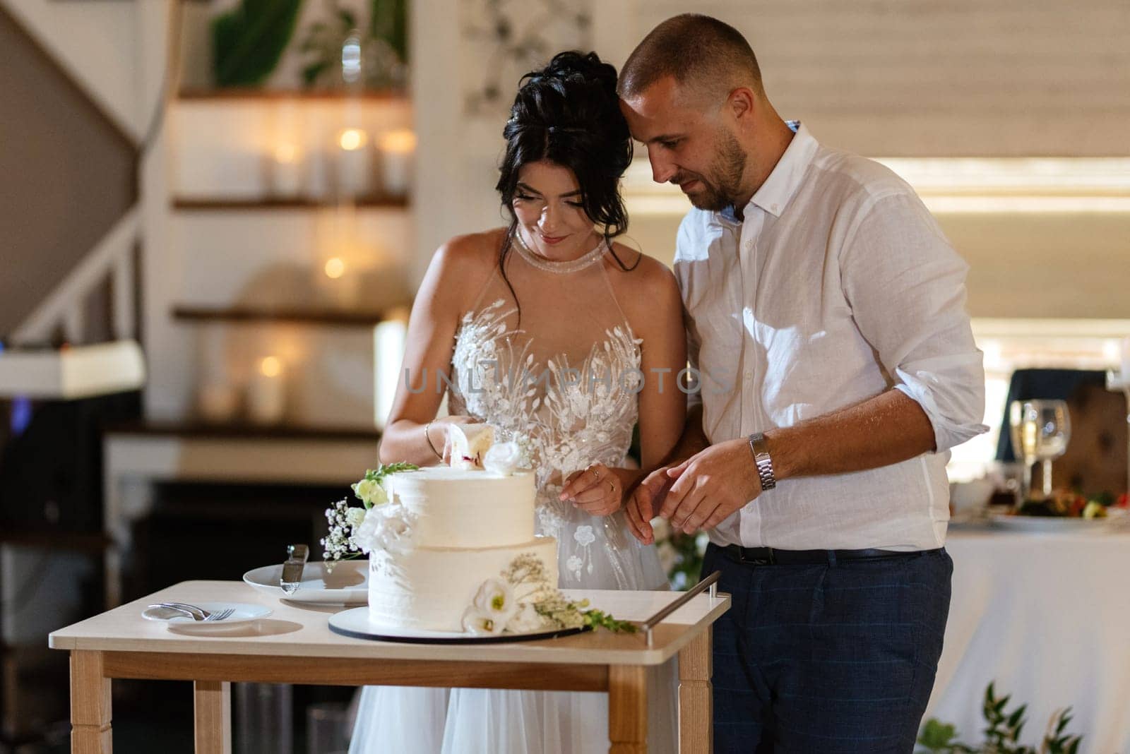 newlyweds happily cut and taste the wedding cake by Andreua
