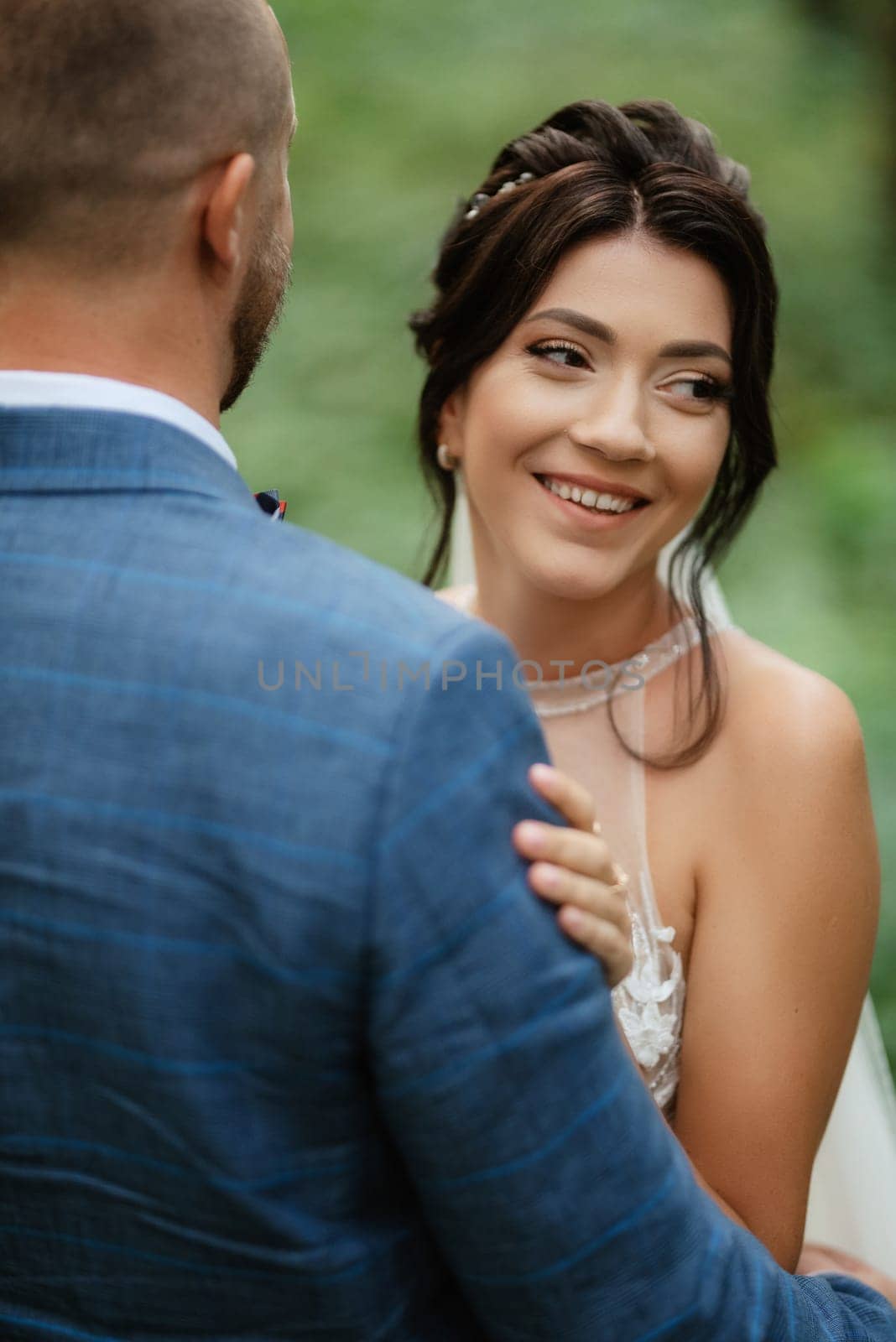 wedding walk of the bride and groom in the deciduous forest in summer