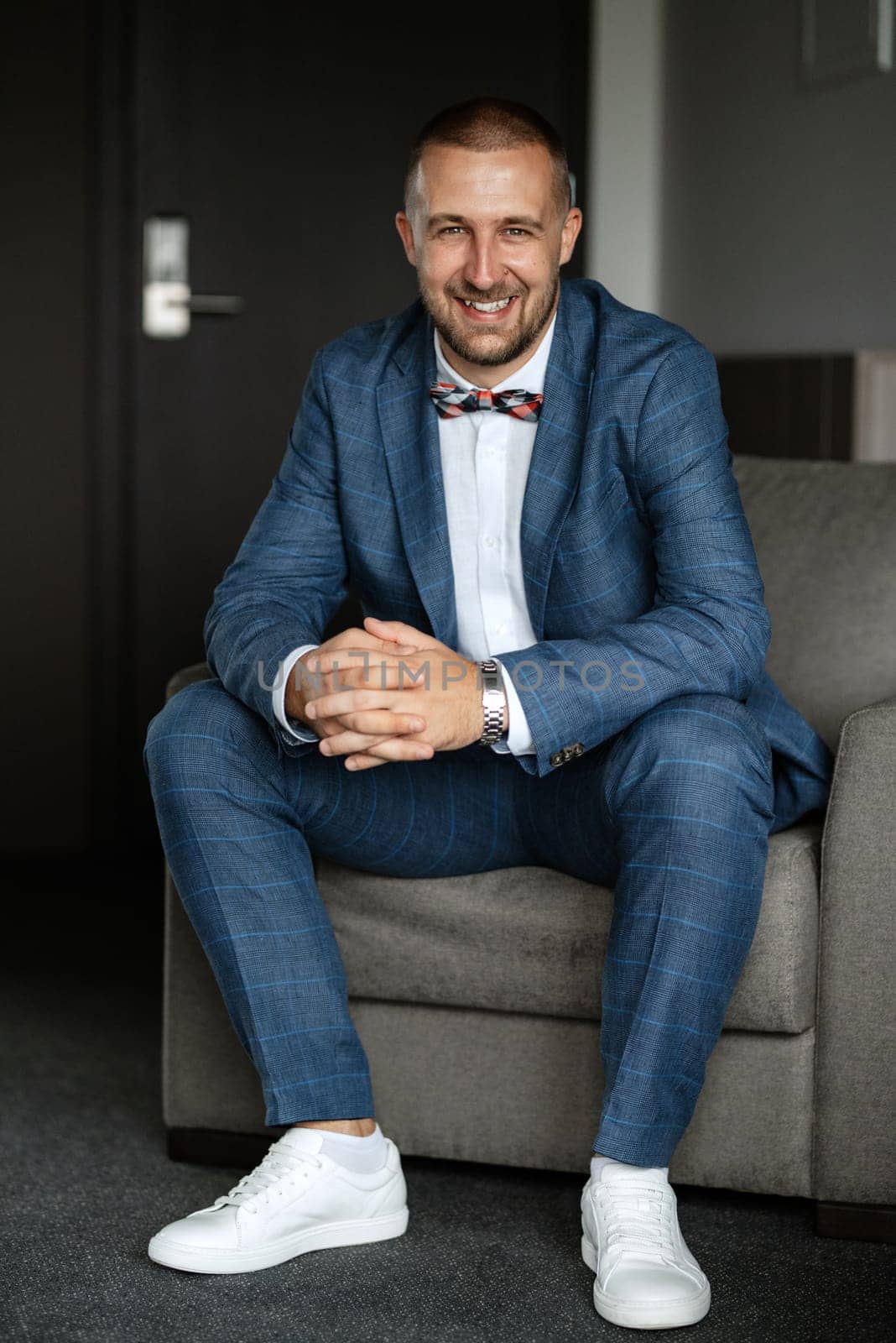 portrait of smiling groom with beard in blue color suit