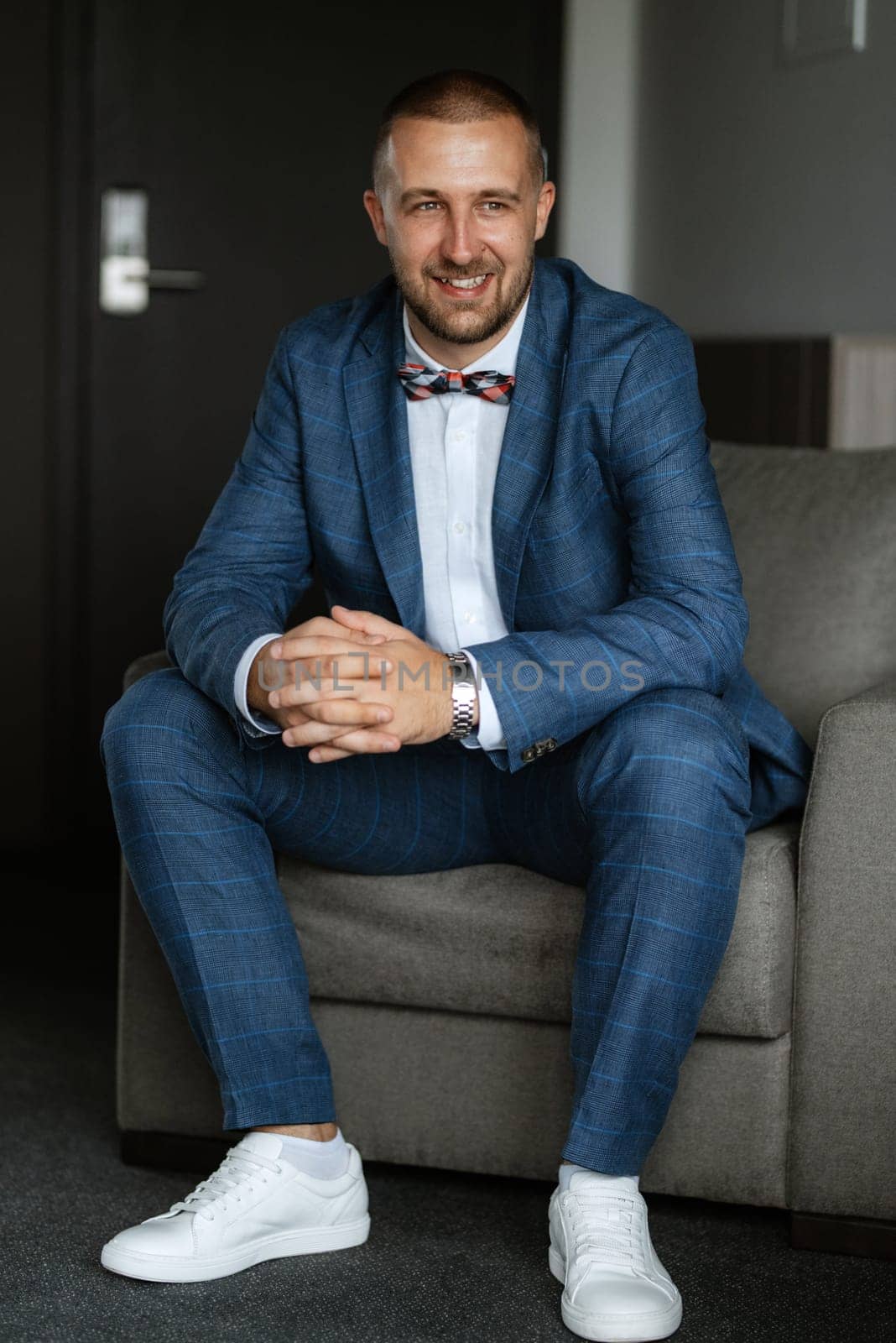 portrait of smiling groom with beard in blue color suit
