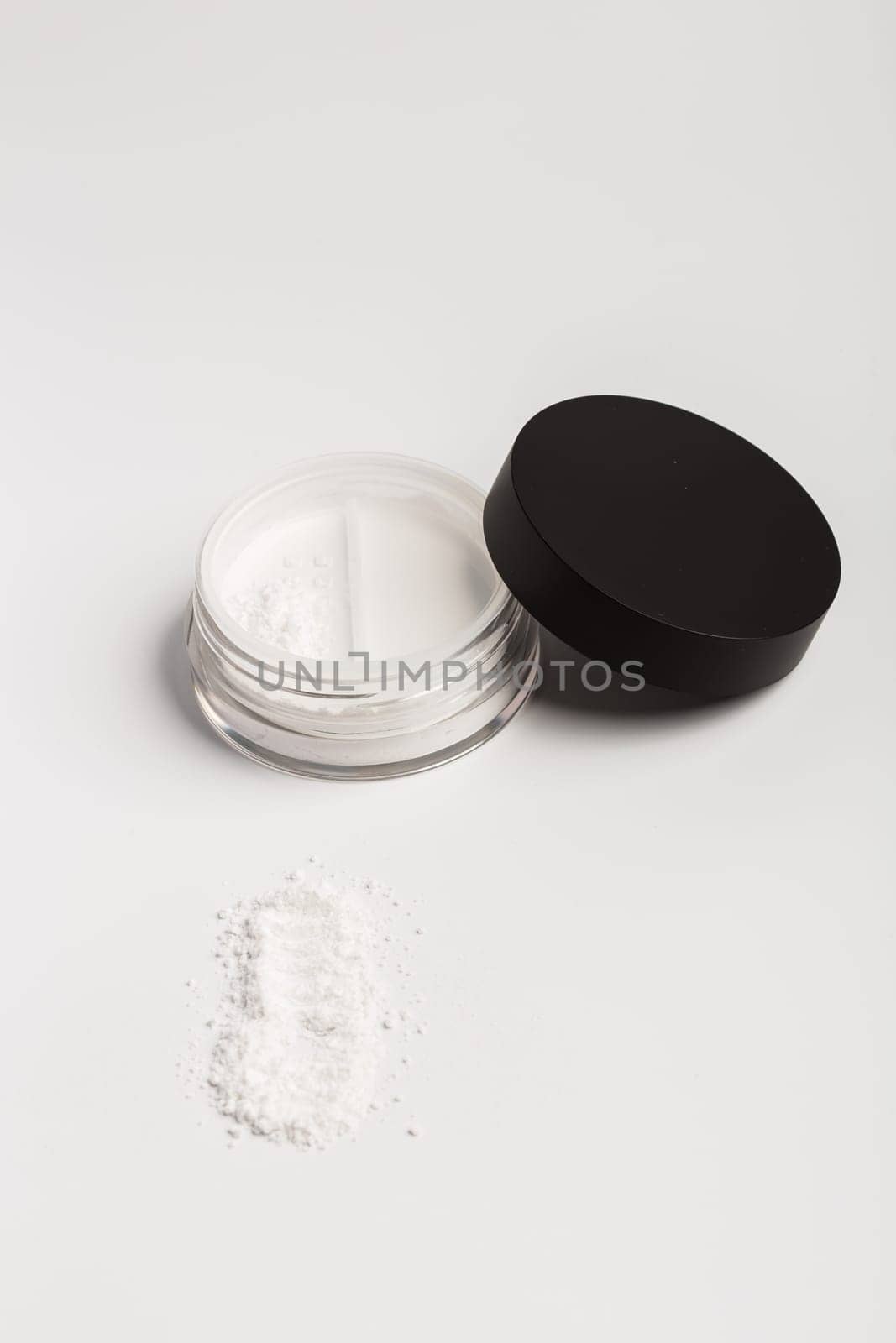 White mineral makeup in container with twist seal sifter powder isolated on white background by Satura86