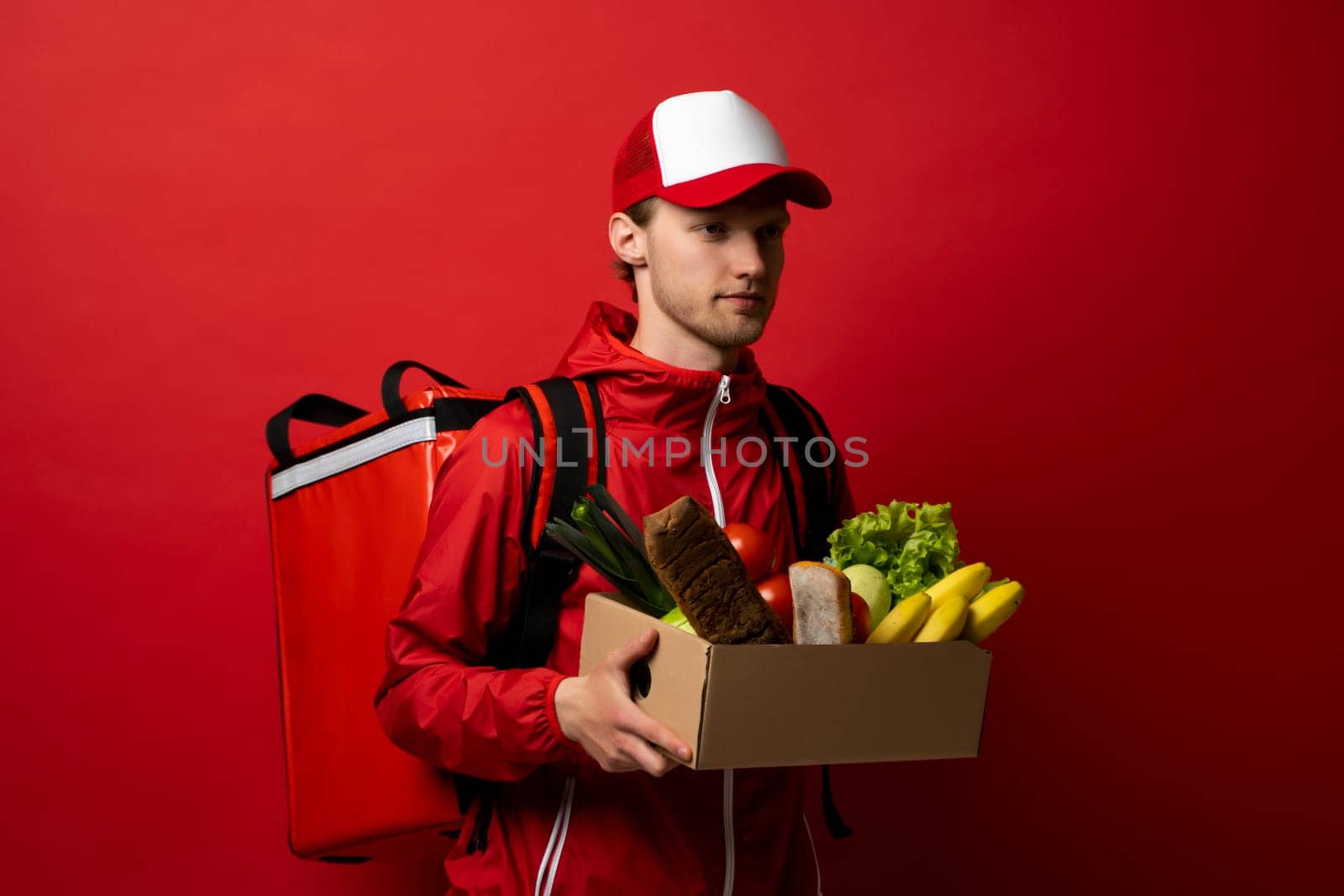 Delivery Concept - Handsome delivery man carrying package box of grocery food and drink from store