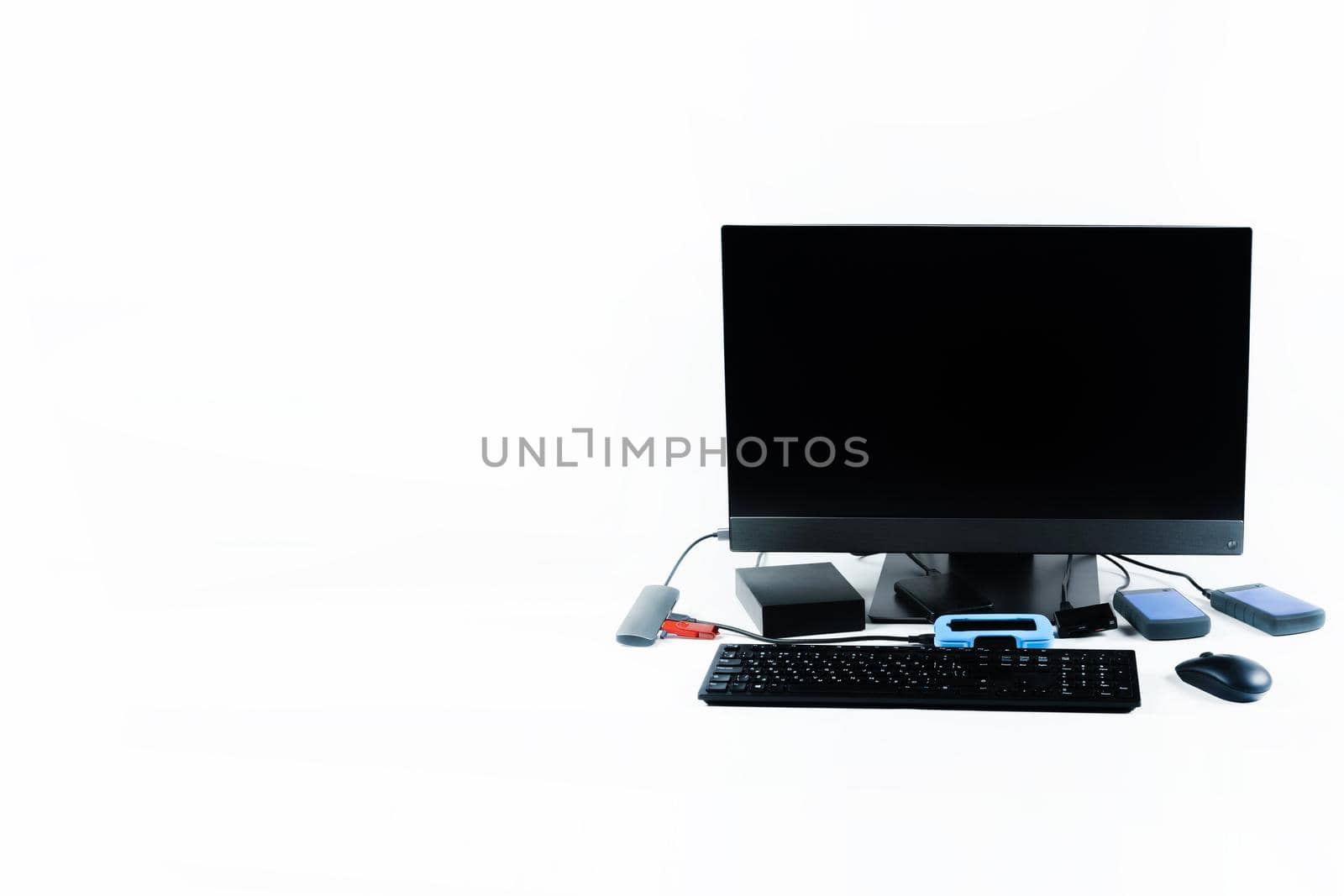 Multiple external hard drives connected to a monoblock on a white background.Computer with hard drive.