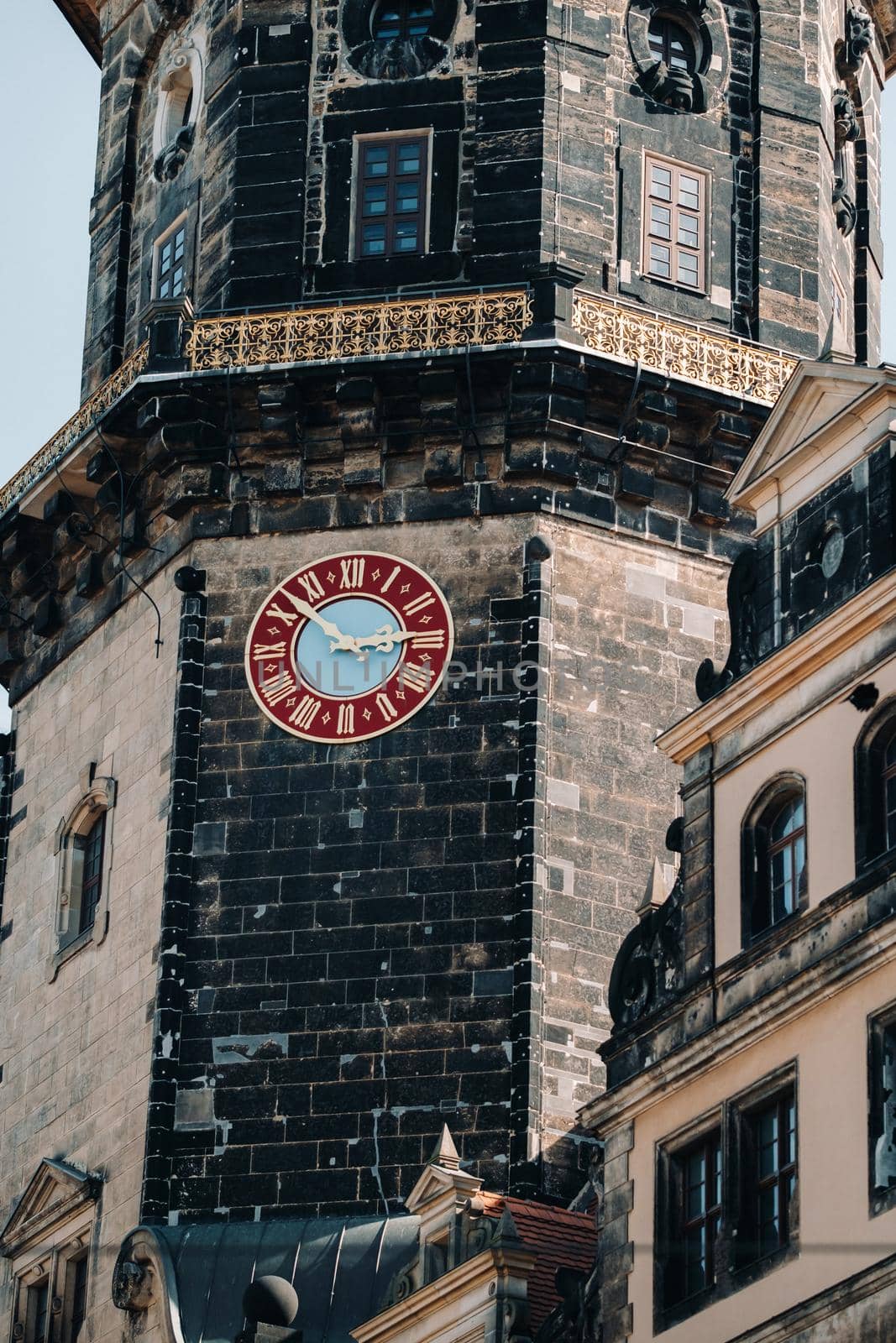 Dresden, the red great clock of the Dresden castle tower, the residence of the old kings in the city center, the Baroque Museum complex, illuminated by the sun.