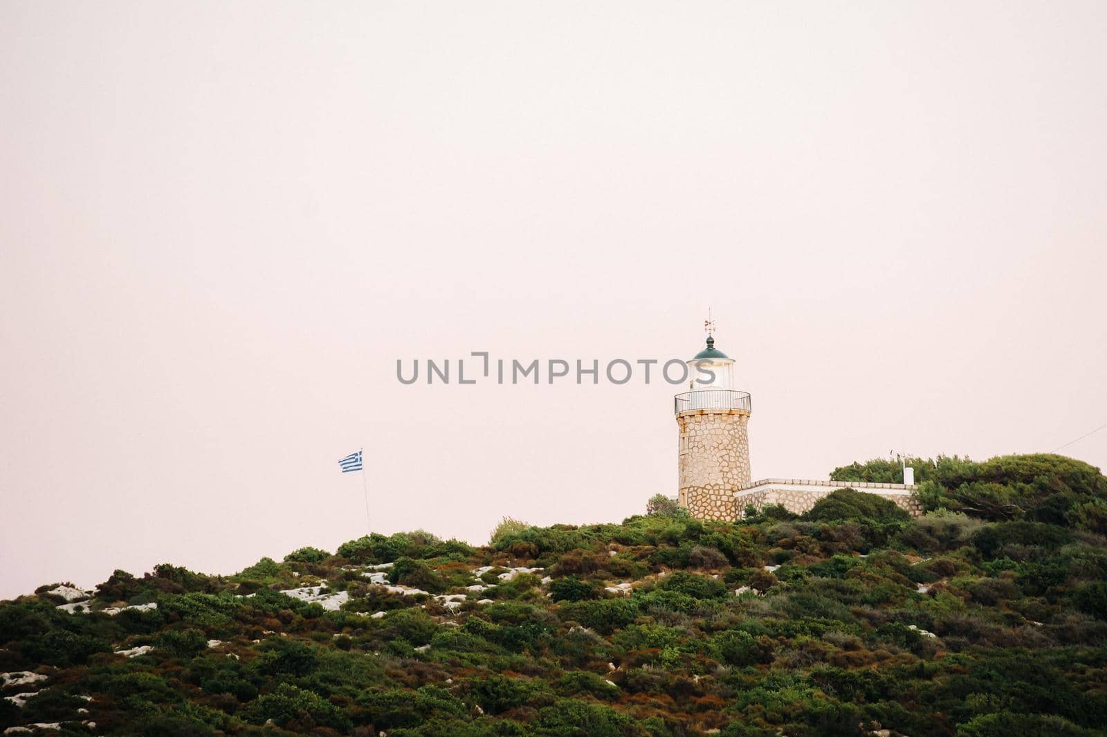 lighthouse and Greek flag on the island of Zakynthos.Greece.
