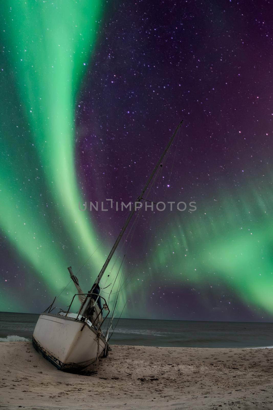 Aurora borealis over a shipwreck off the coast of Uttakleiv Beach in Norway