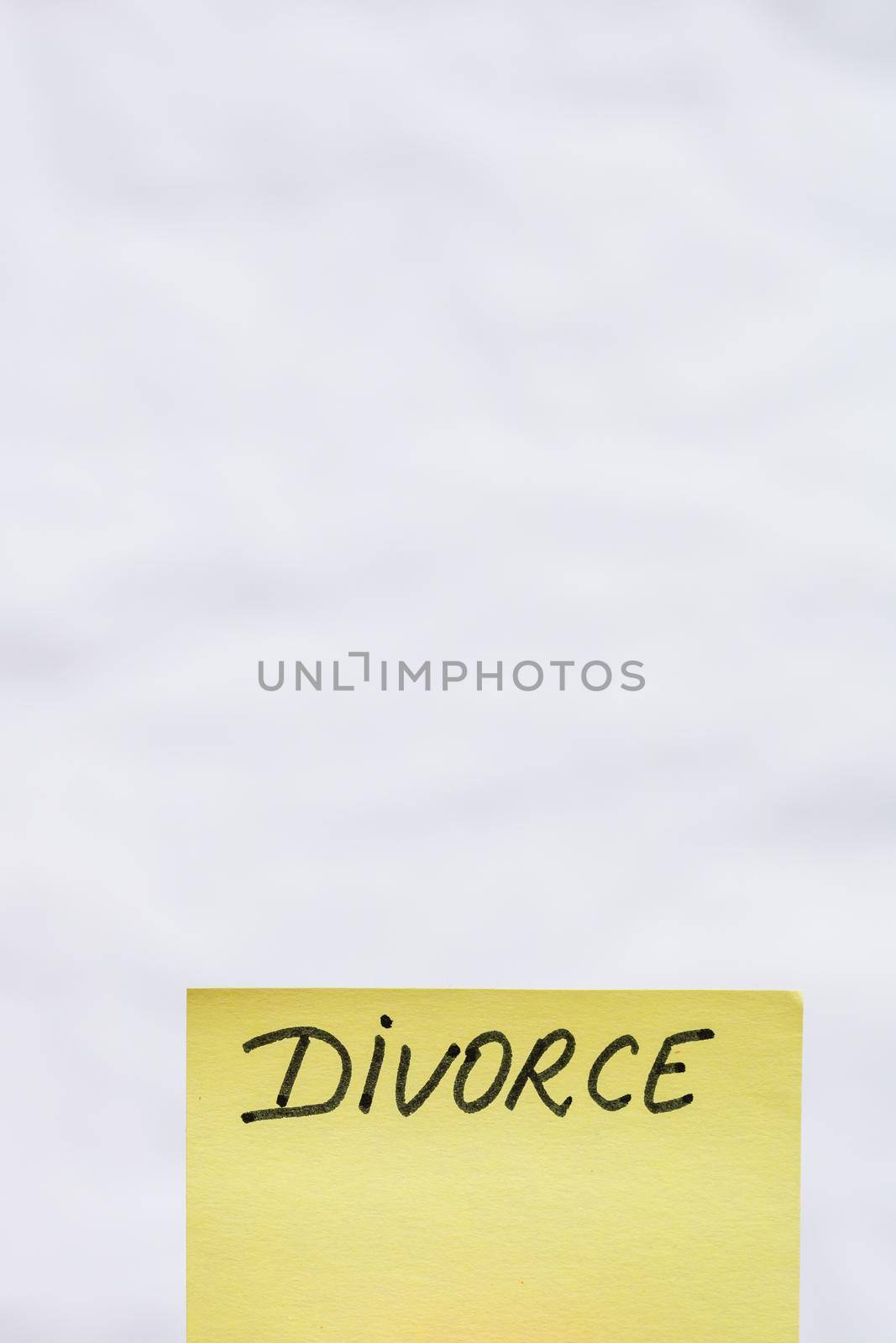 Divorce handwriting text close up isolated on yellow paper with copy space.