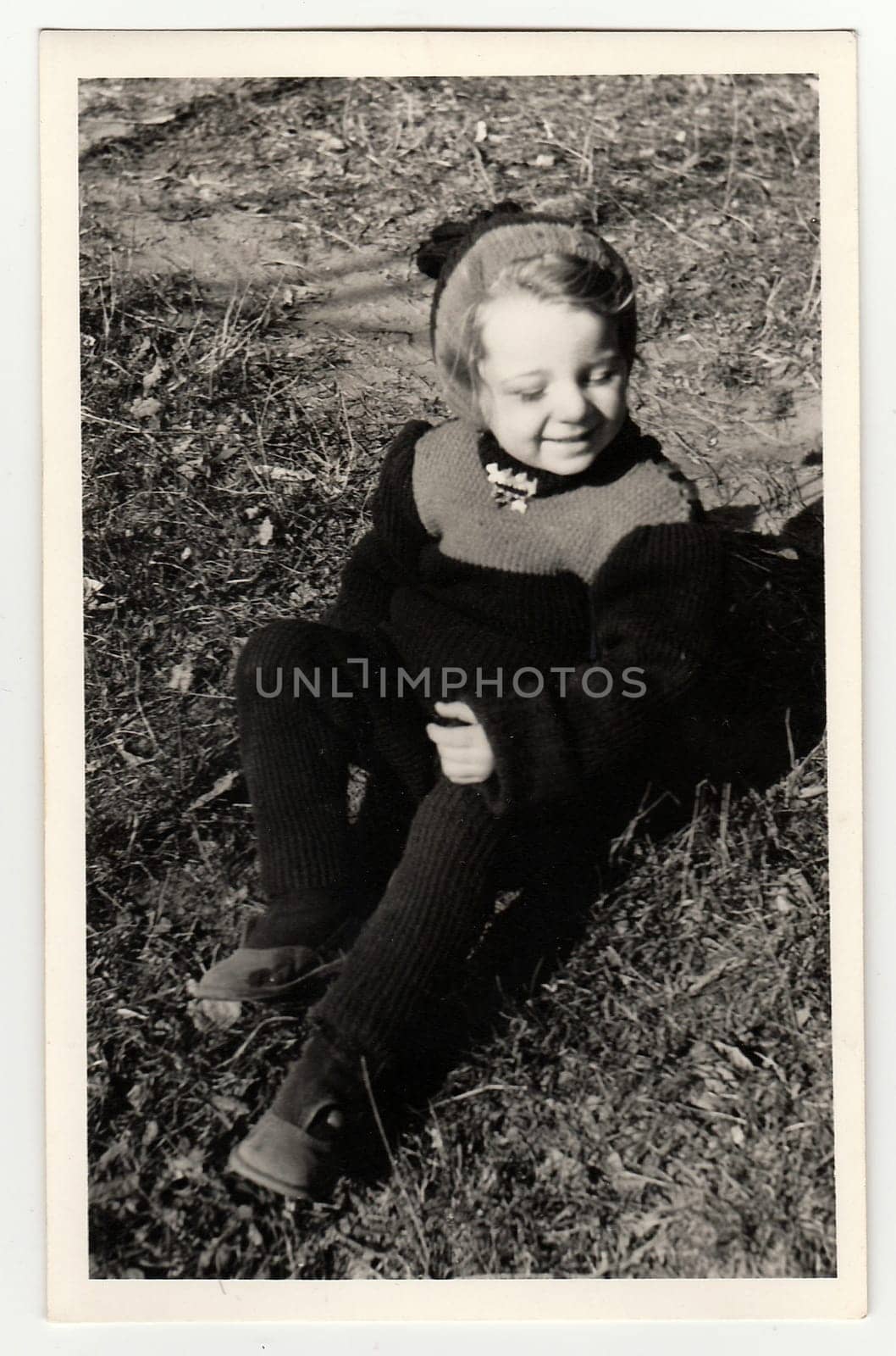 HODONIN, THE CZECHOSLOVAK REPUBLIC, CIRCA 1941: Vintage photo shows a small girl sits on grass, circa 1941