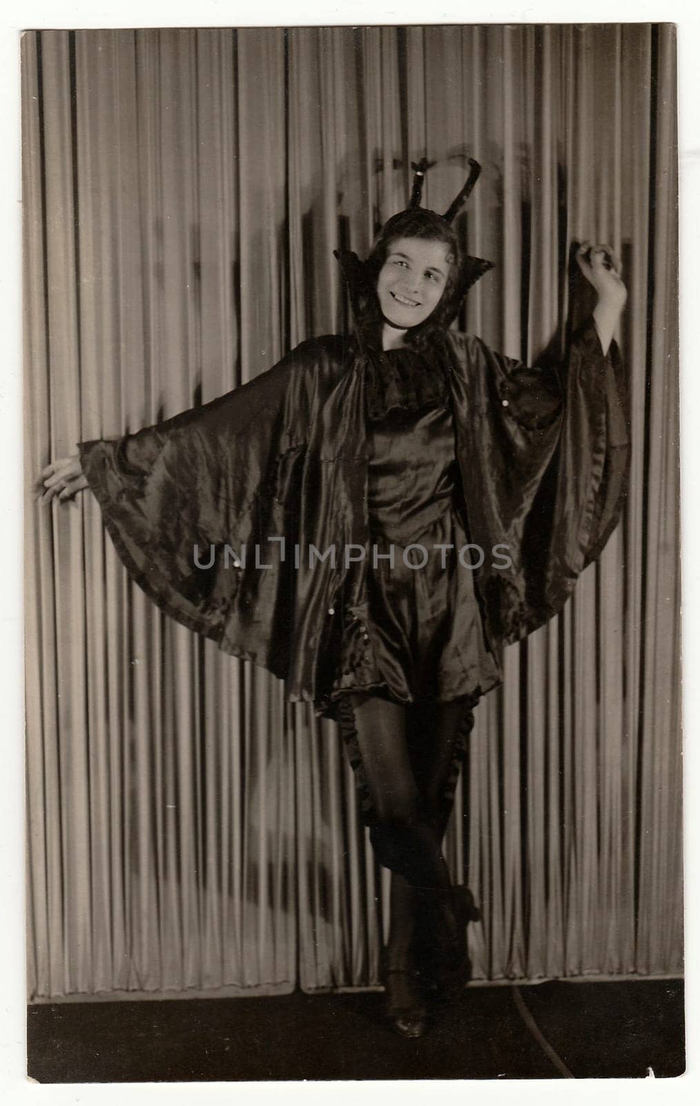 Vintage portrait photo shows young girl in a retro carnival costum (devil costum). Photo studio portrait, circa 1930s. by roman_nerud