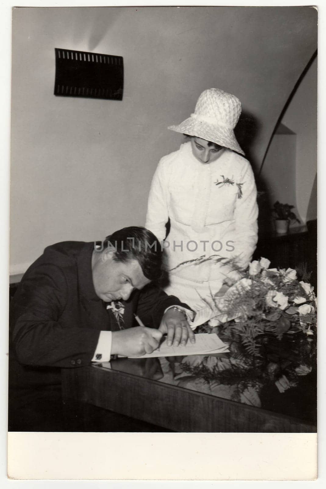 A vintage photo shows wedding photo (signaturing after wedding ceremony), circa 1970. by roman_nerud