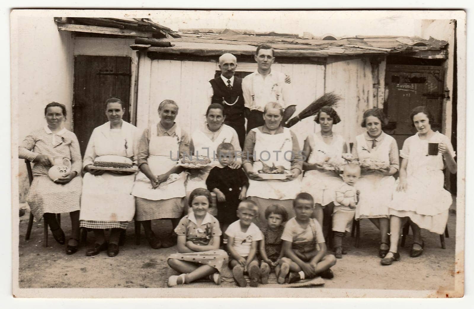 A vintage photo shows people in the back yard (during rural feast), circa 1920. by roman_nerud