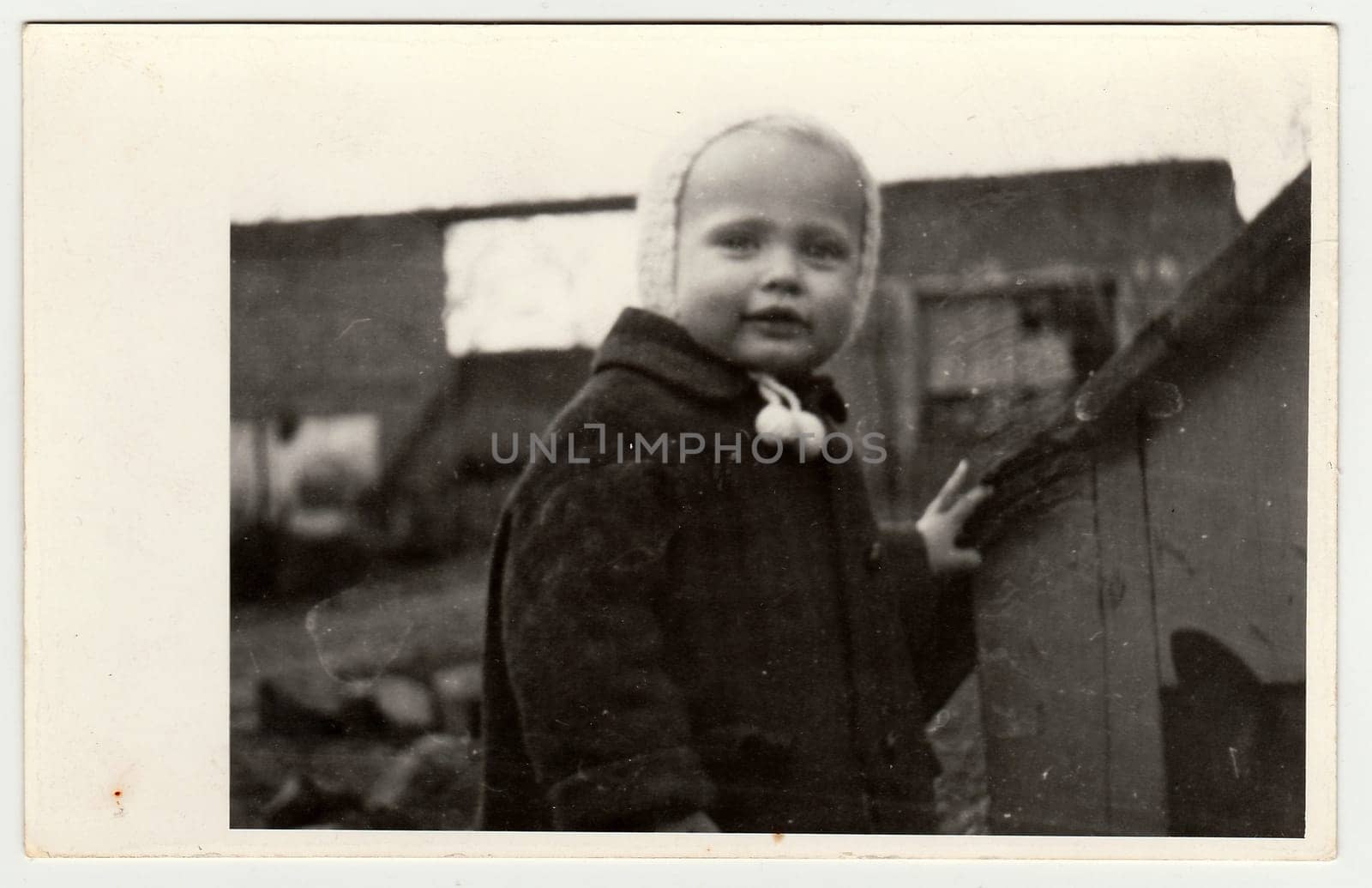 Vintage photo shows a small girl and kannel (doghouse), circa 1942. by roman_nerud