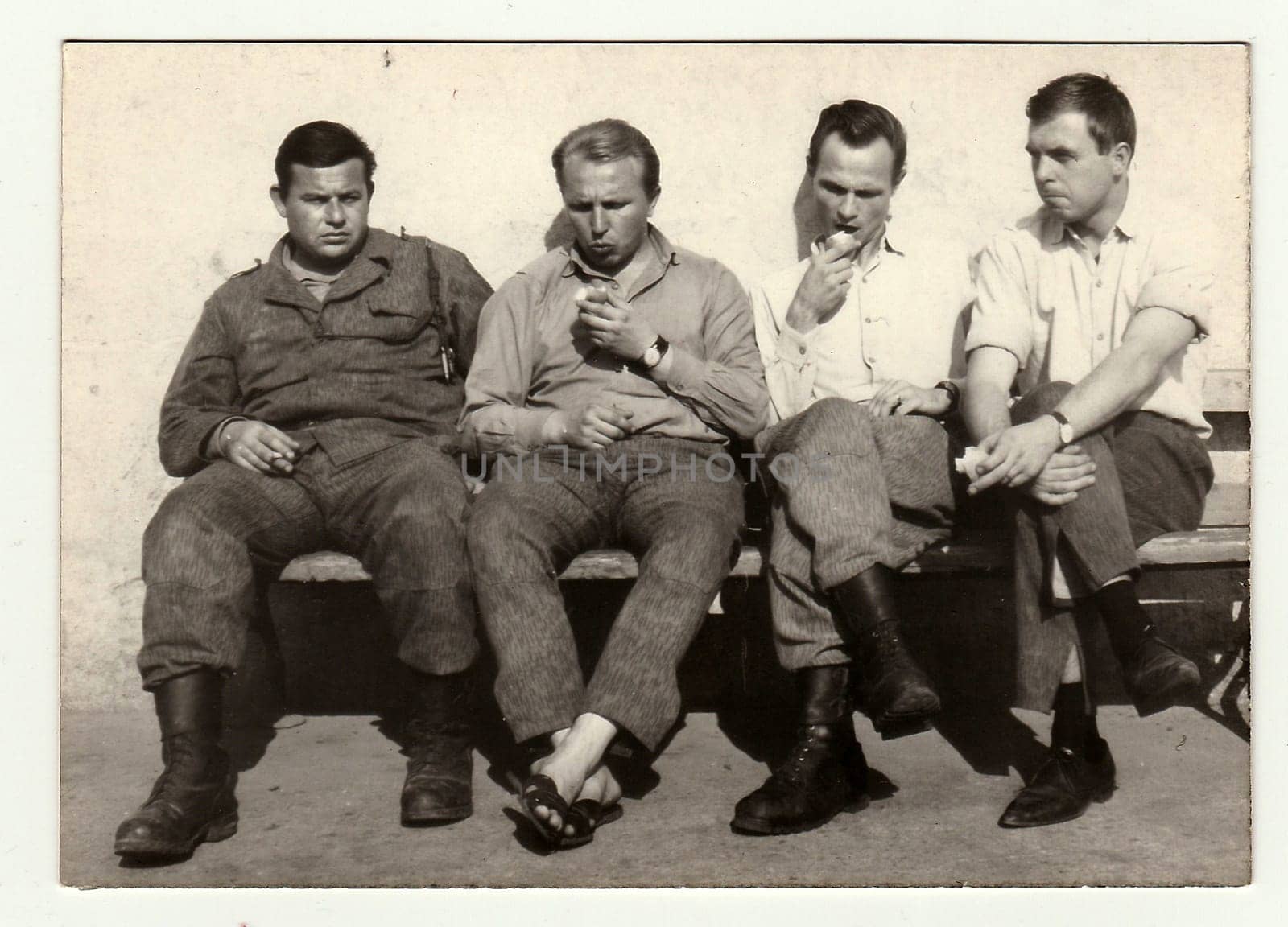 A vintage photo shows soldiers during a rest. by roman_nerud