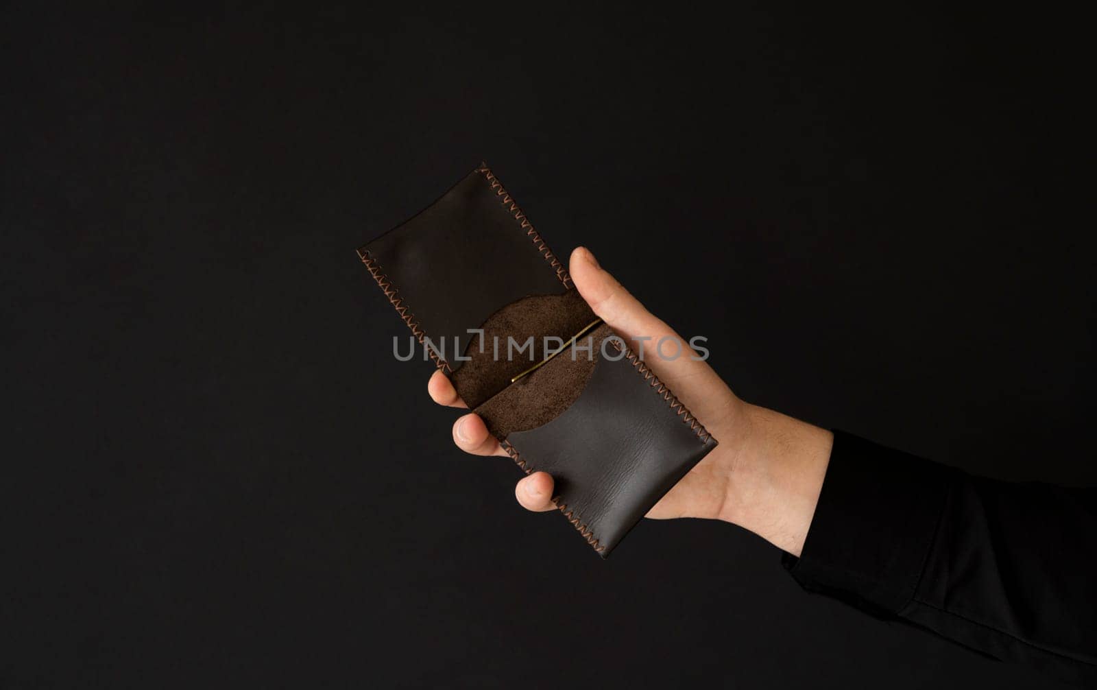 Brown empty men's business handmade leather card holder in a man's hand